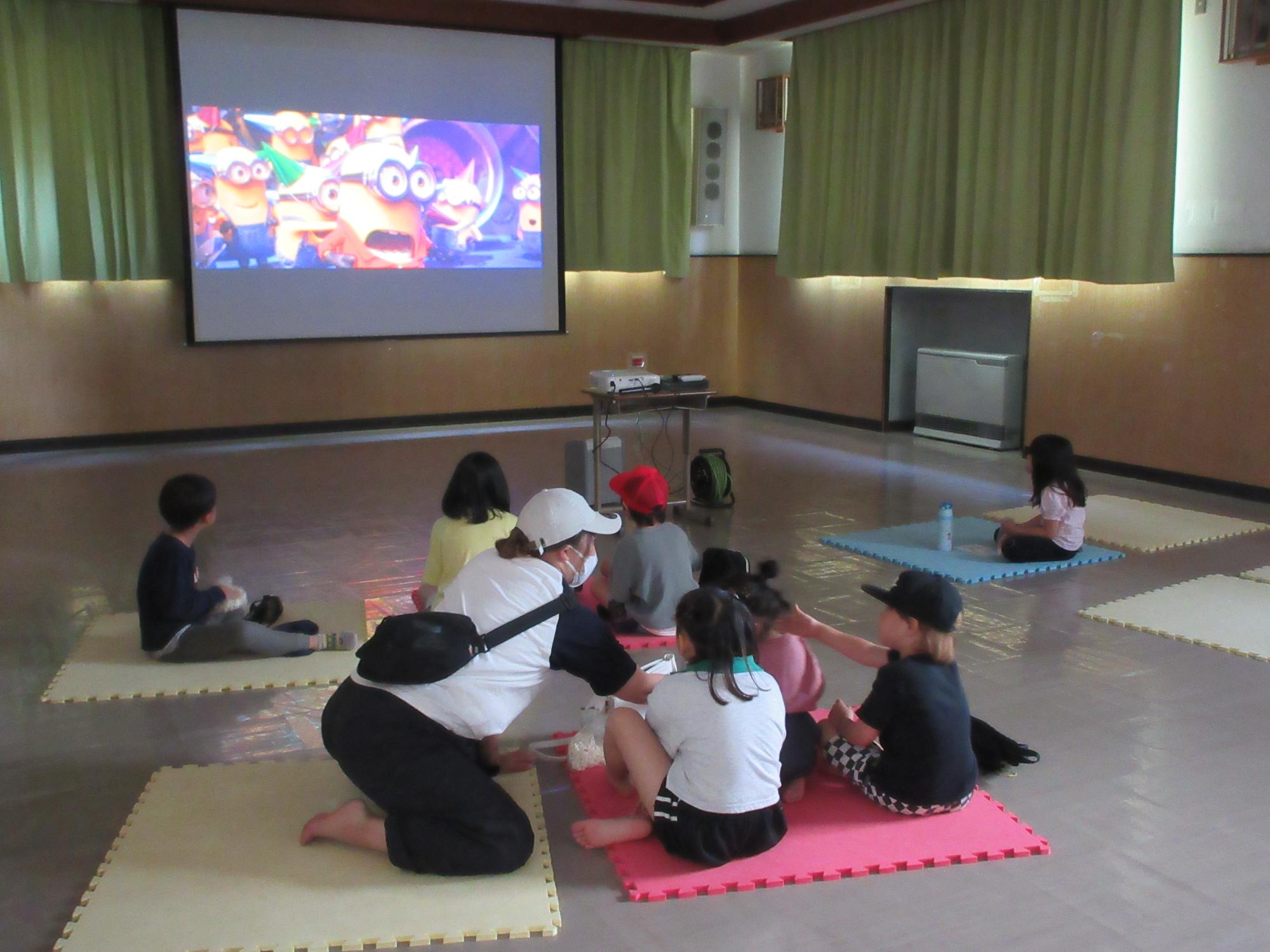 映画を鑑賞する子どもと保護者の様子の写真