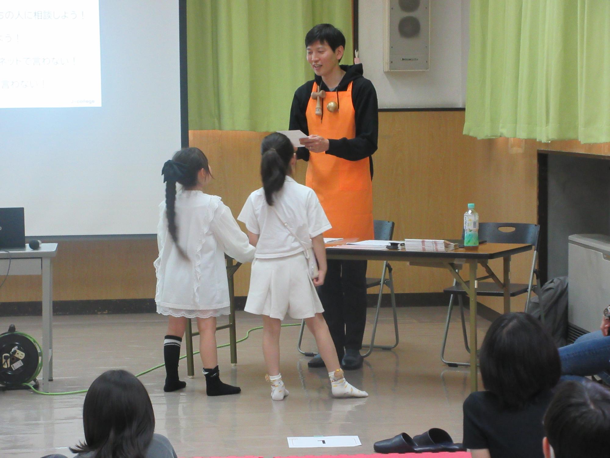 認定証を渡す講師と受け取っている子どもの写真