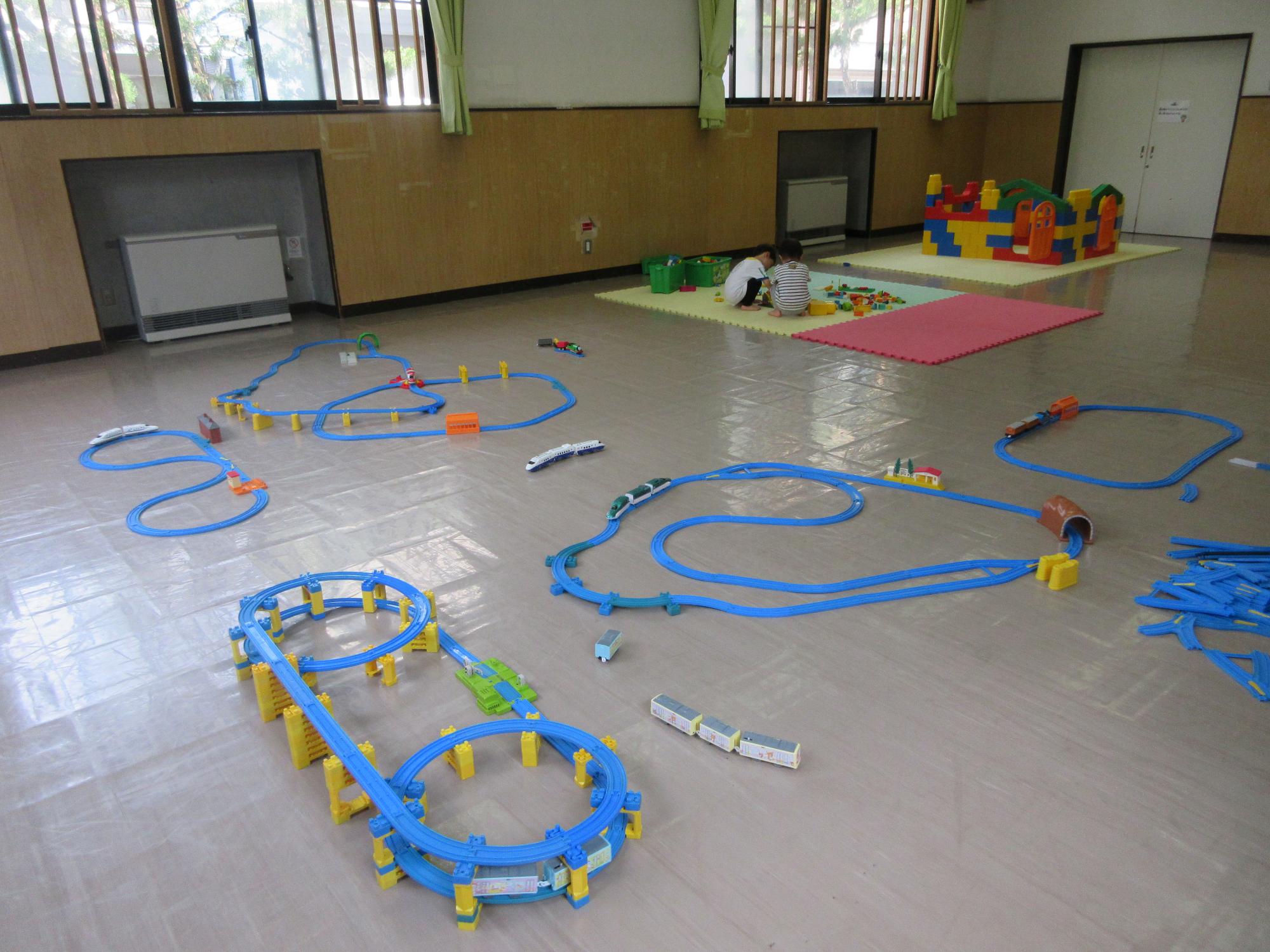 プラレールとブロックの部屋で遊ぶ幼児の写真