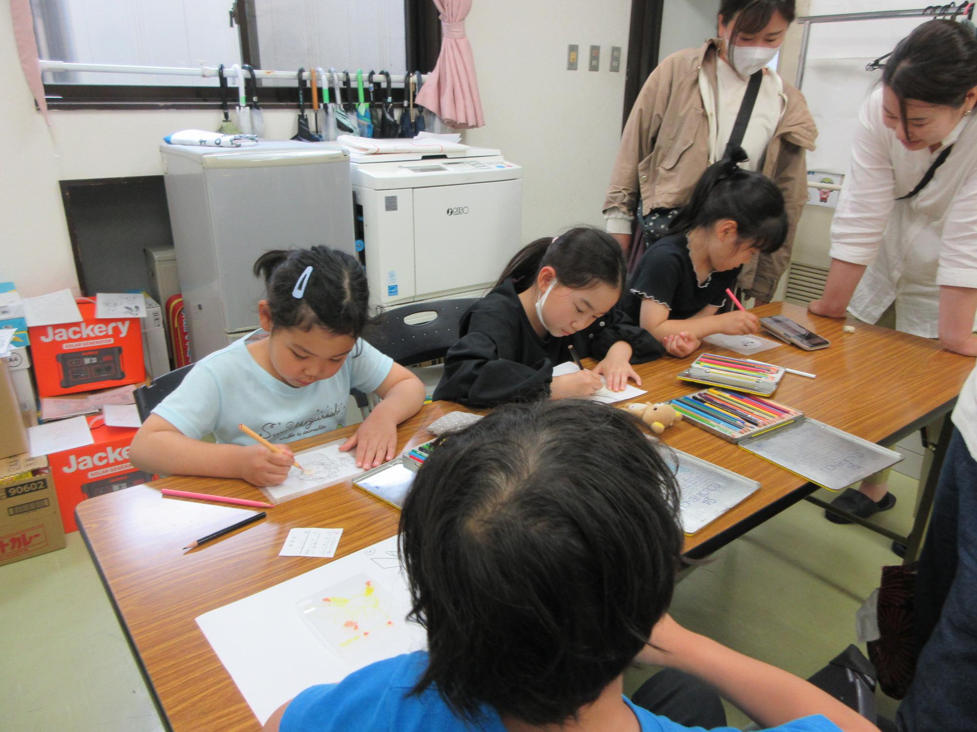 プラバンシートに絵を描く子どもの様子の写真