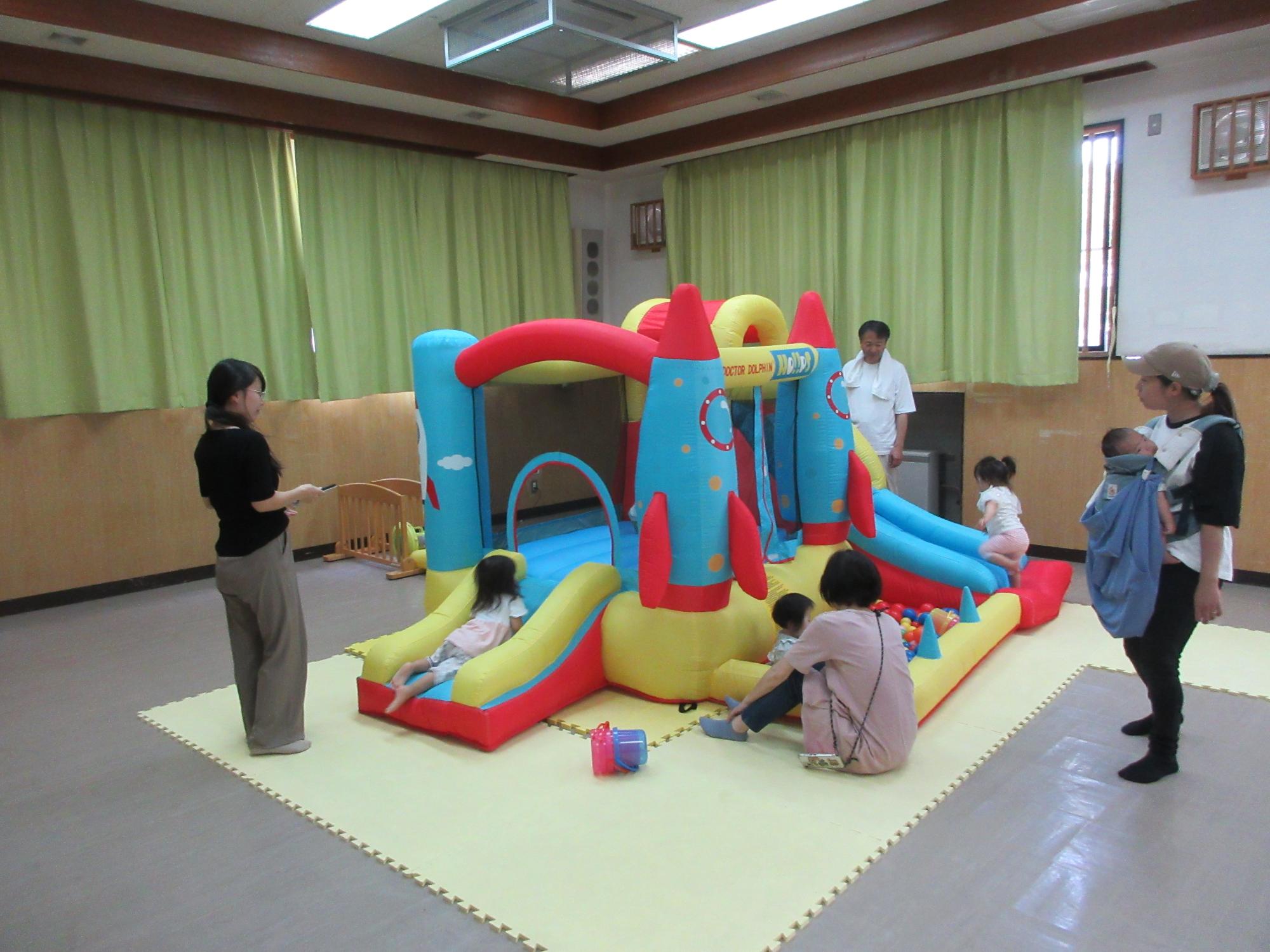 スライダーで遊ぶ幼児親子の様子