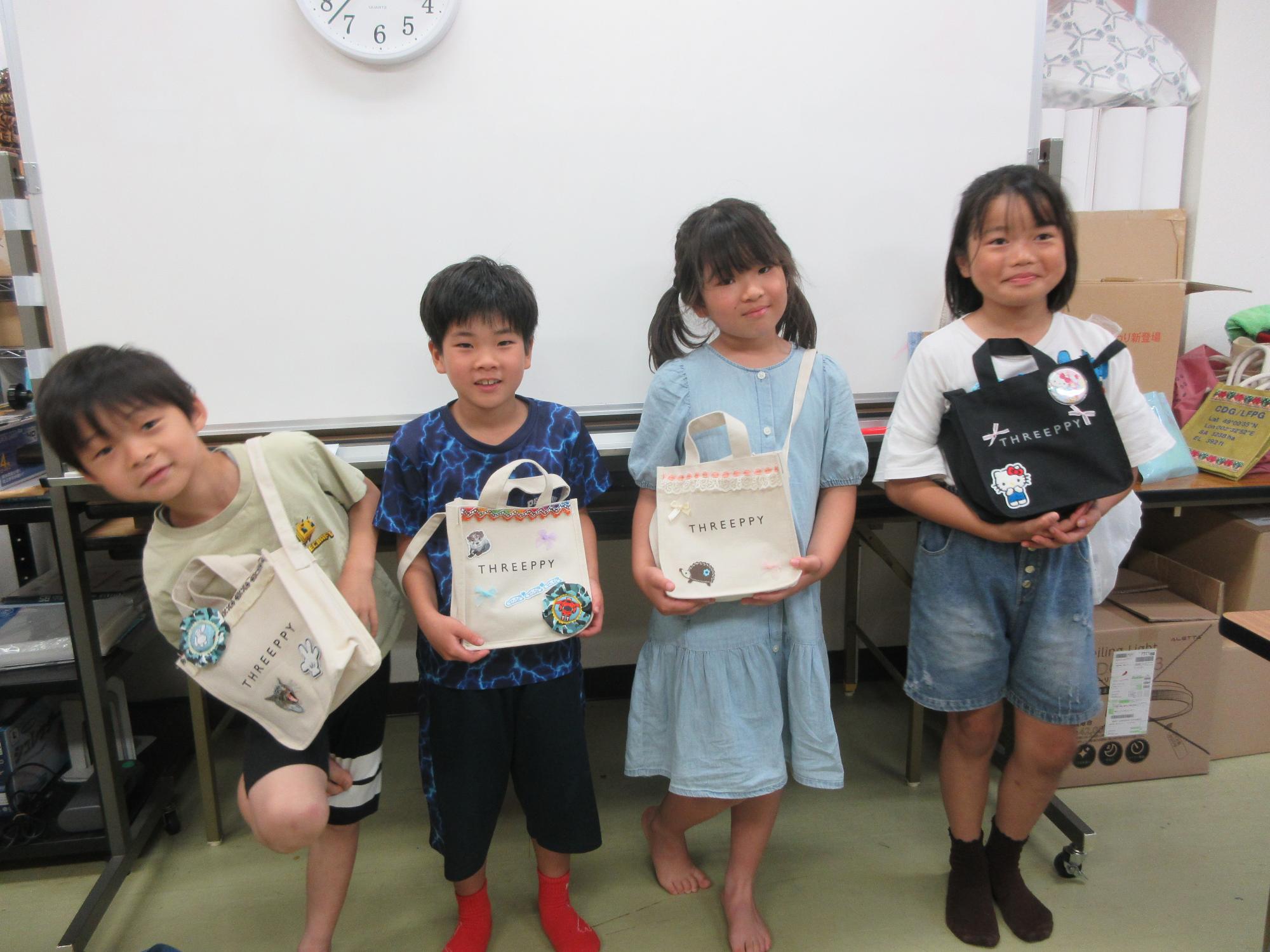 完成したバッグを持つ小学生の様子
