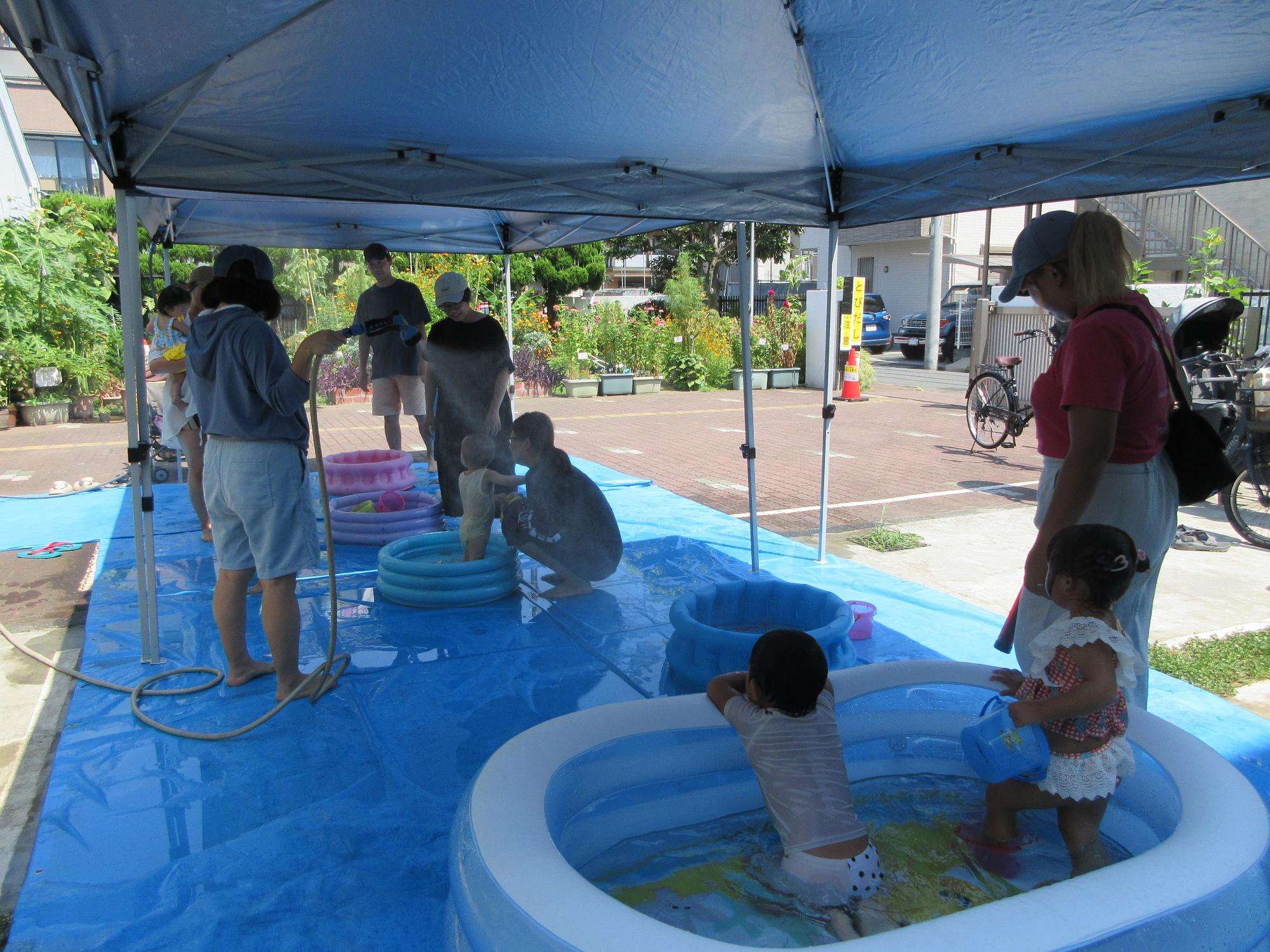 乳幼児親子が水遊びをしている様子