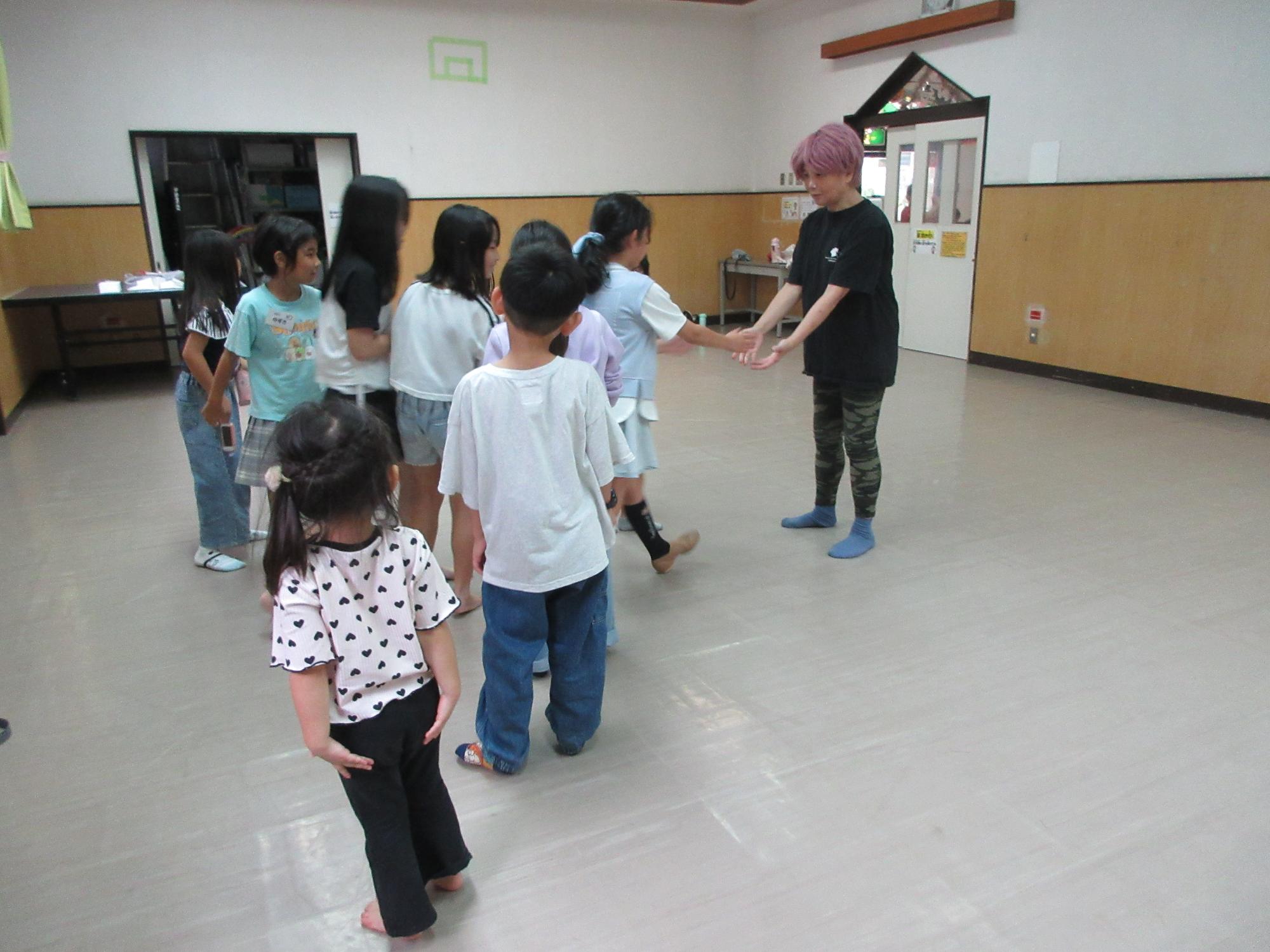 ダンスの先生と児童たちが握手をしている様子