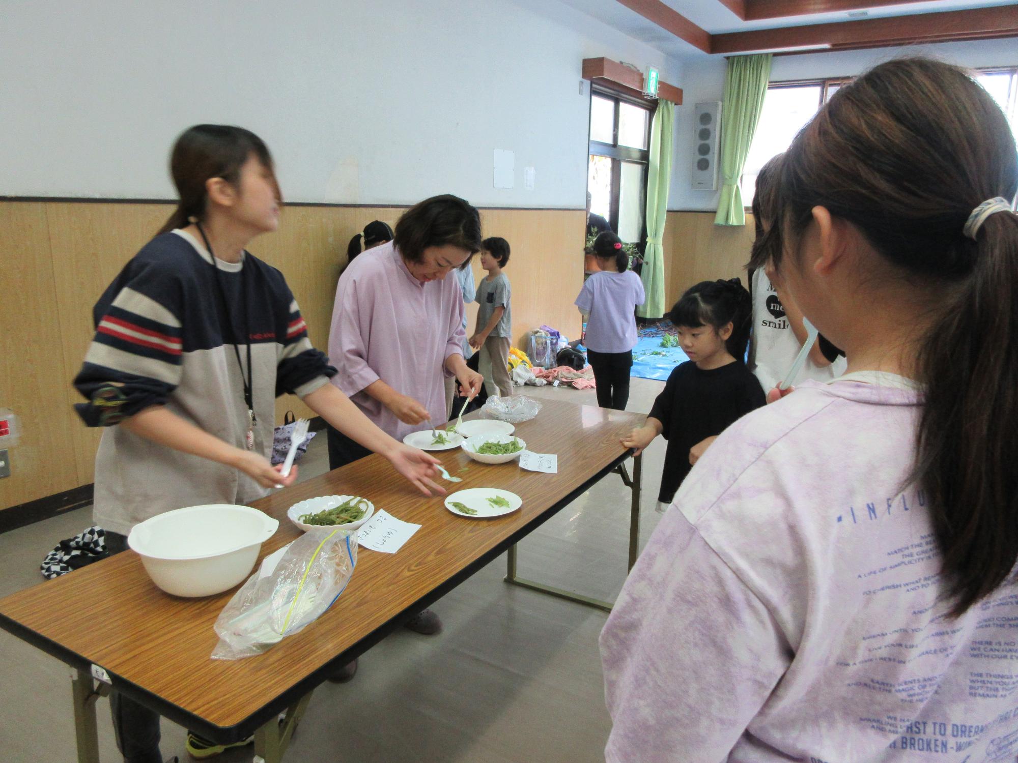 児童たちが芋づるを試食している様子