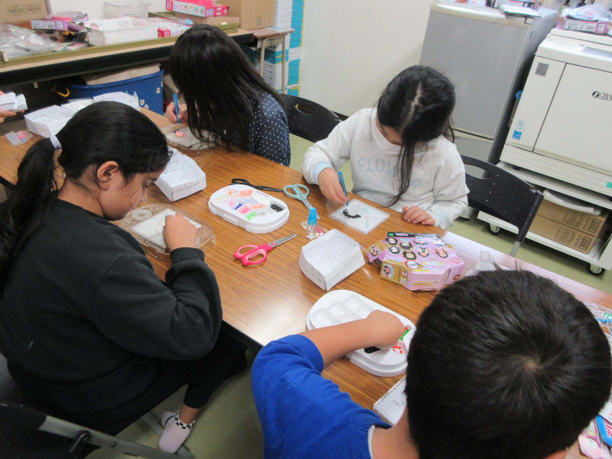 児童たちがビーズストラップ作りをしている様子