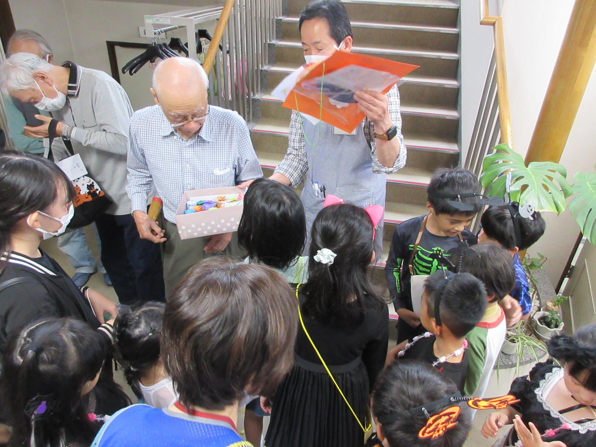 児童たちがお菓子をもらっている様子