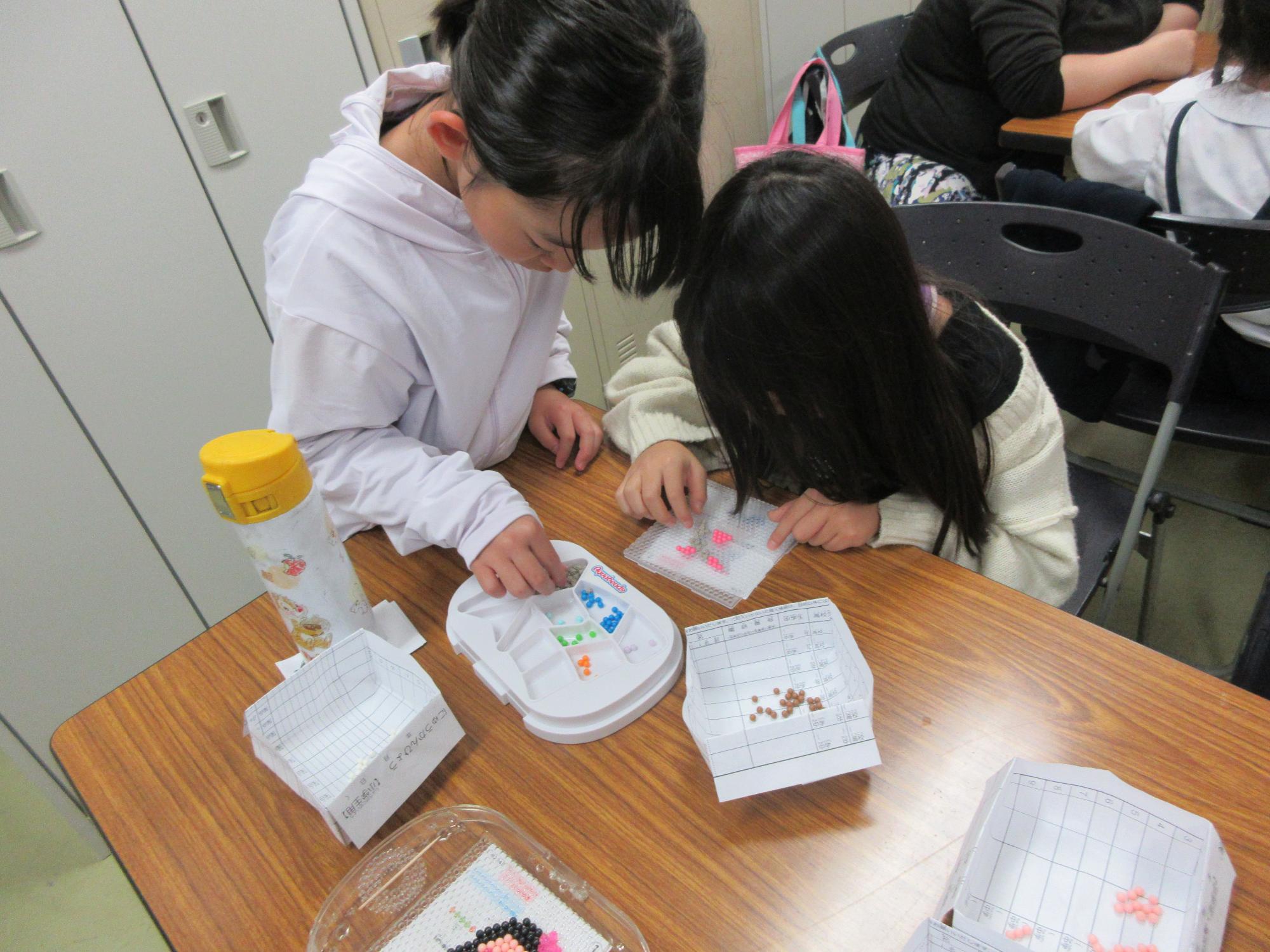児童たちがビーズストラップ作りをしている様子