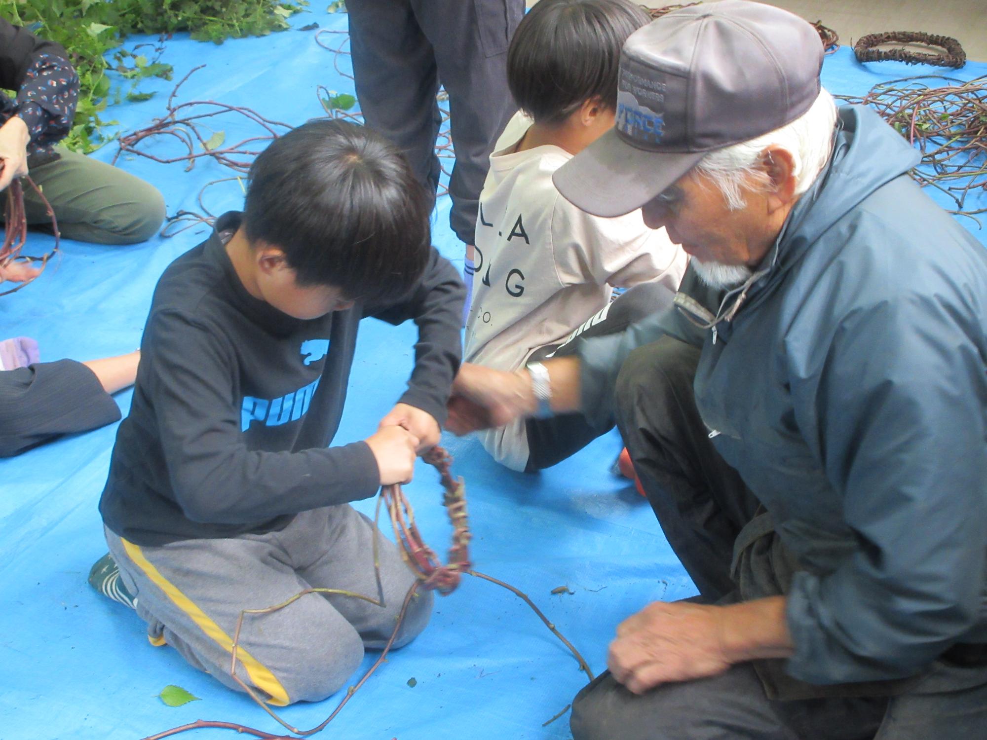 児童がリースづくりを教わっている様子