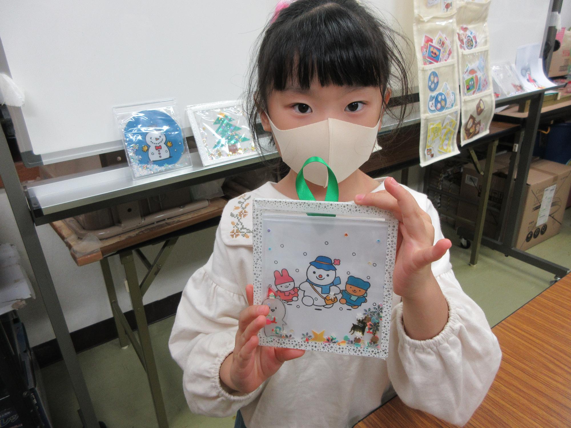 完成したフレームを持つ児童の写真