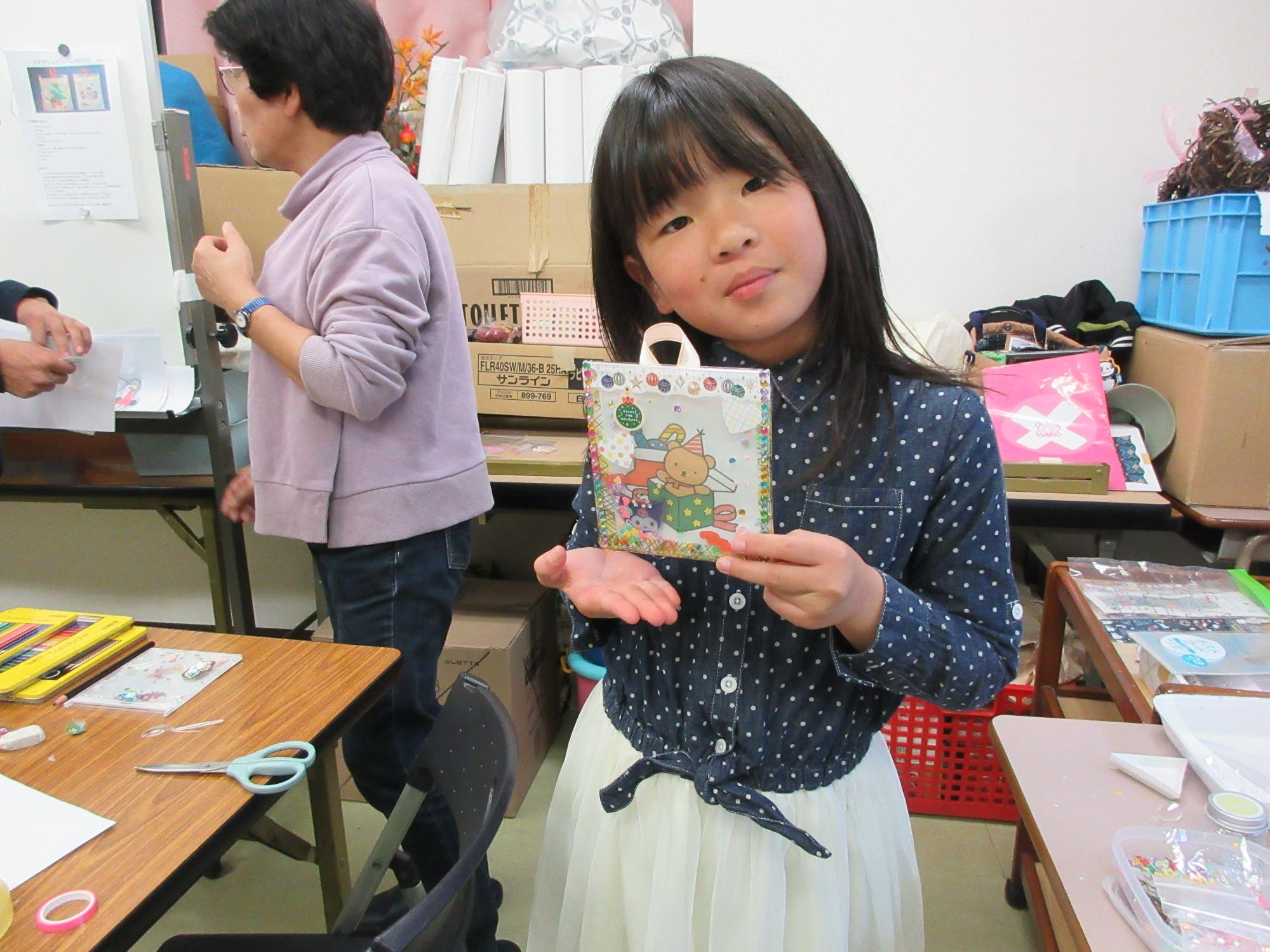 完成したフレームを持つ児童の写真