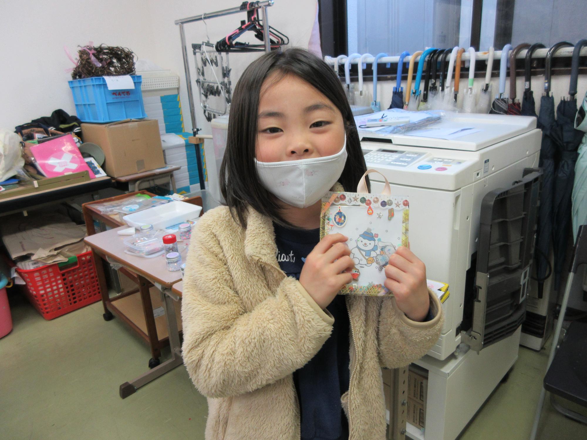 完成したフレームを持つ児童の写真