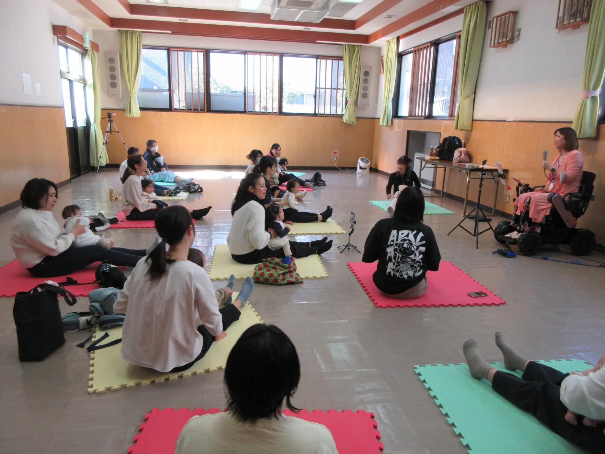 講師の動きに合わせて体を動かす参加者の様子