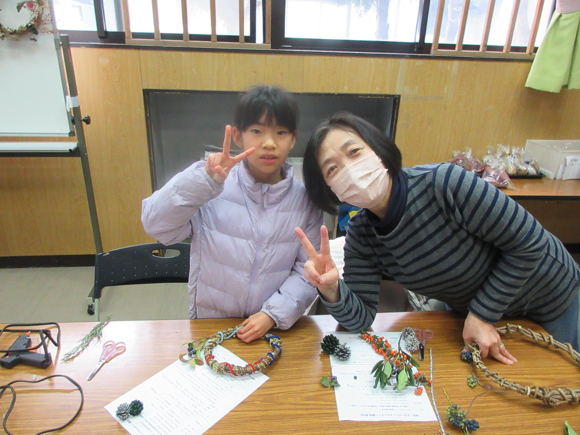 カメラに向かってポーズする小学生と成人の様子