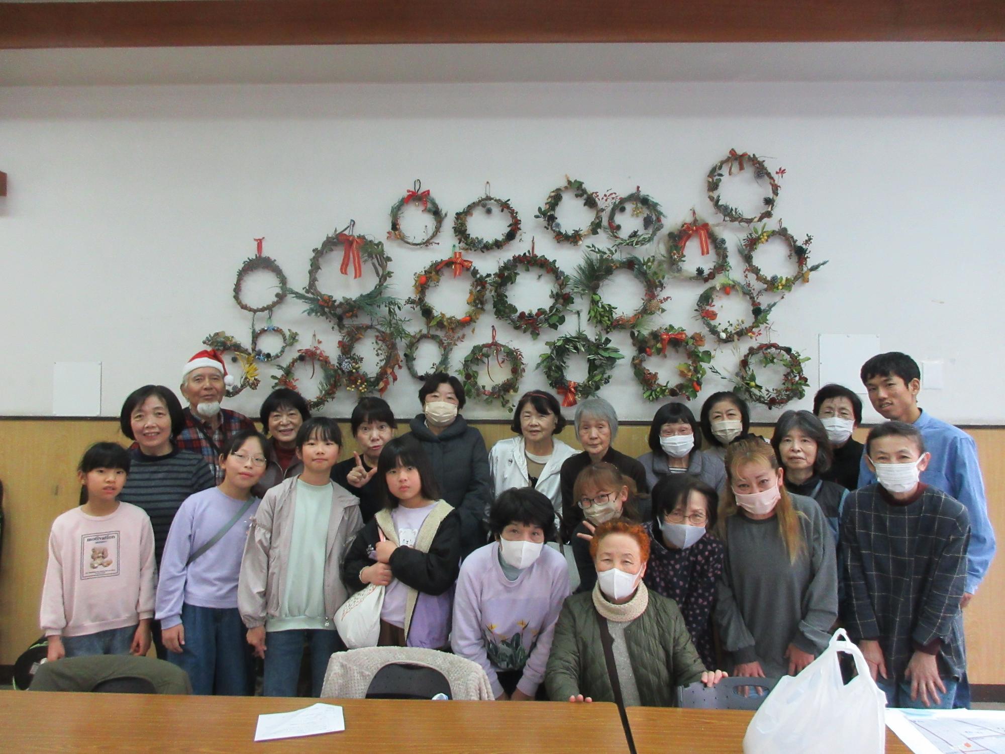 完成したリースと参加者の記念撮影の様子