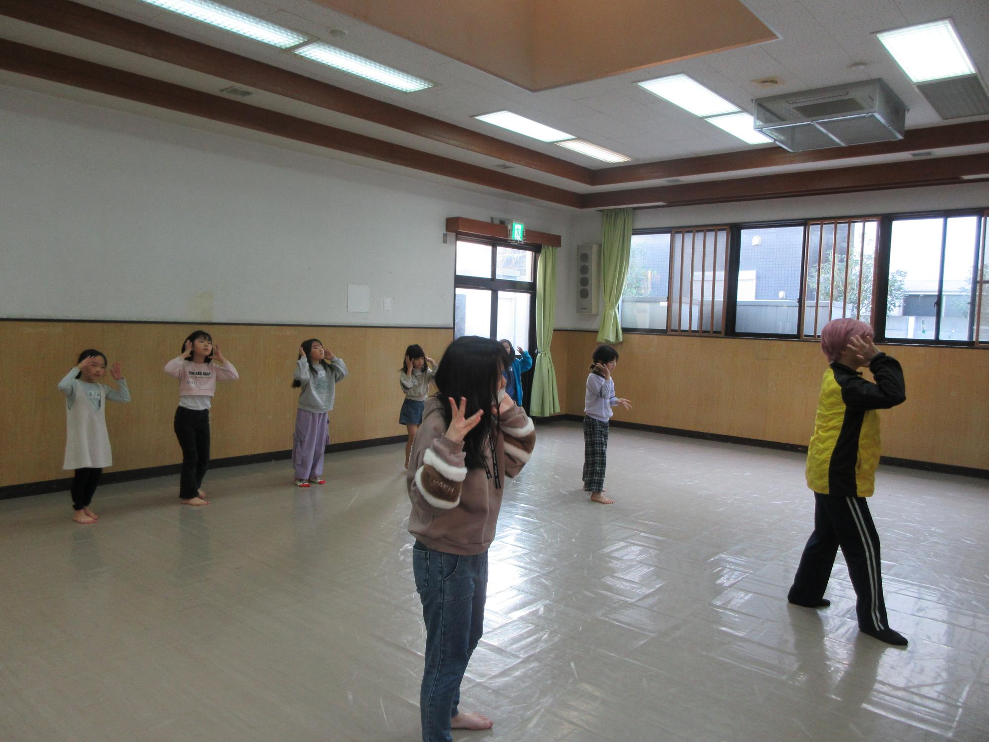 振り付けの確認をする児童と指導する講師