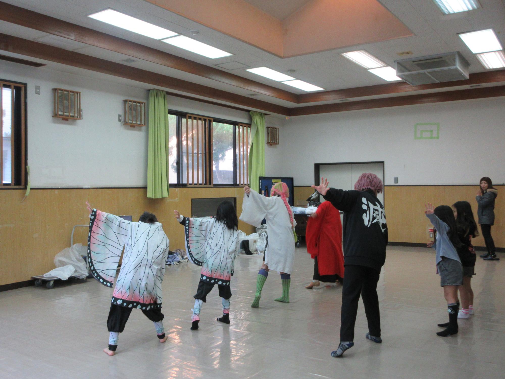 振り付けの確認をする児童と指導する講師