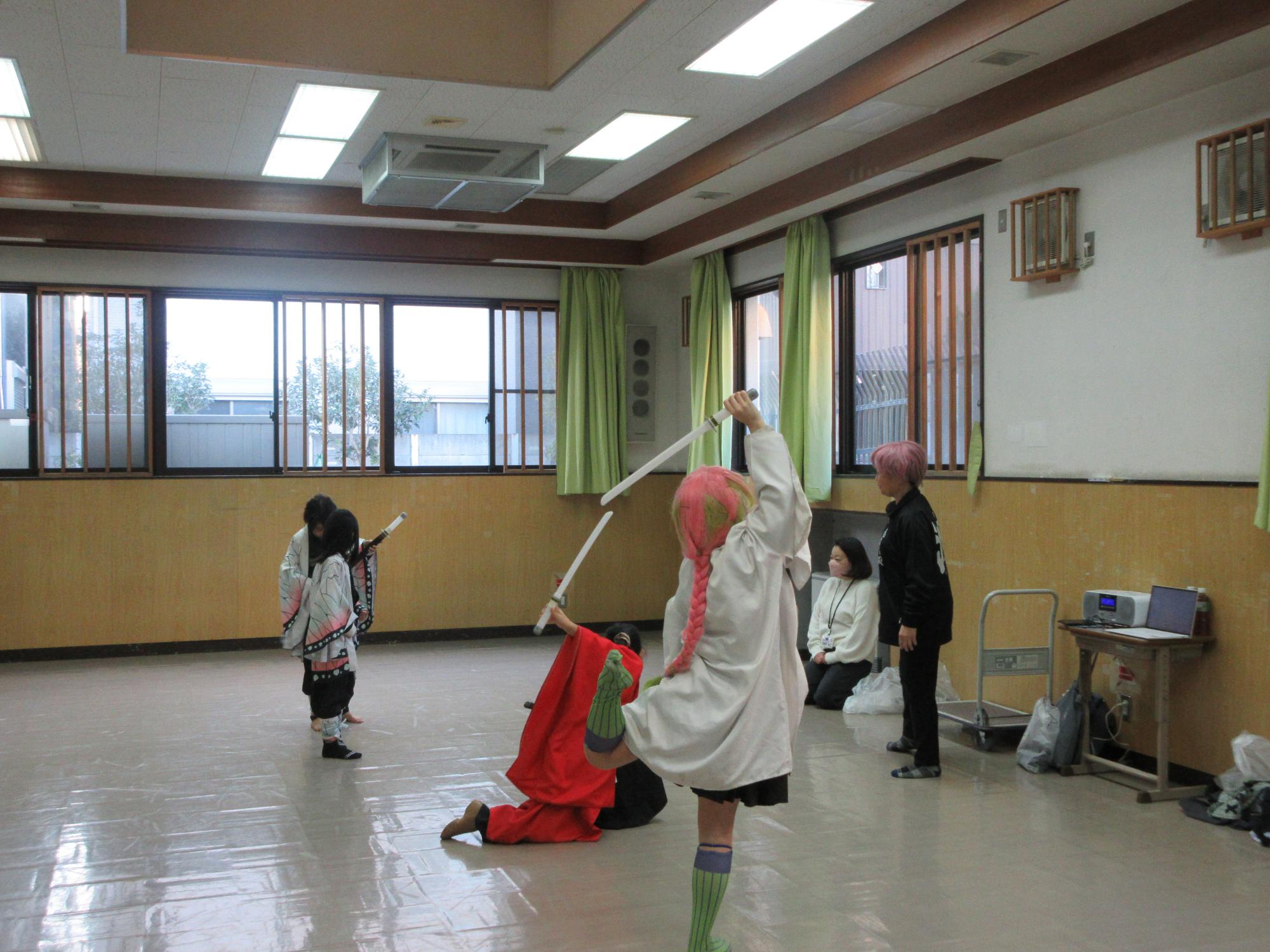 振り付けの確認をする児童と指導する講師