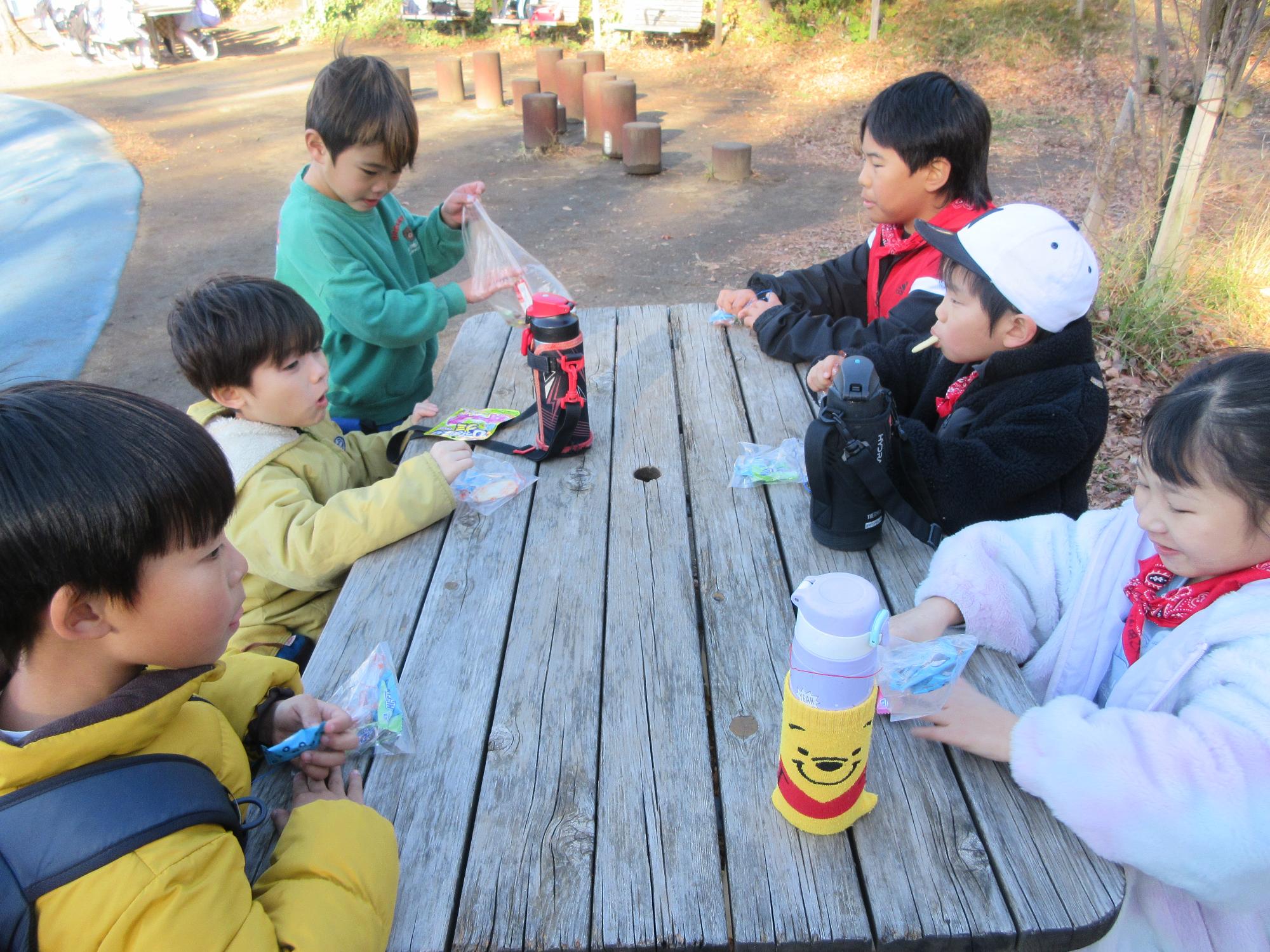 公園でおやつを食べる児童