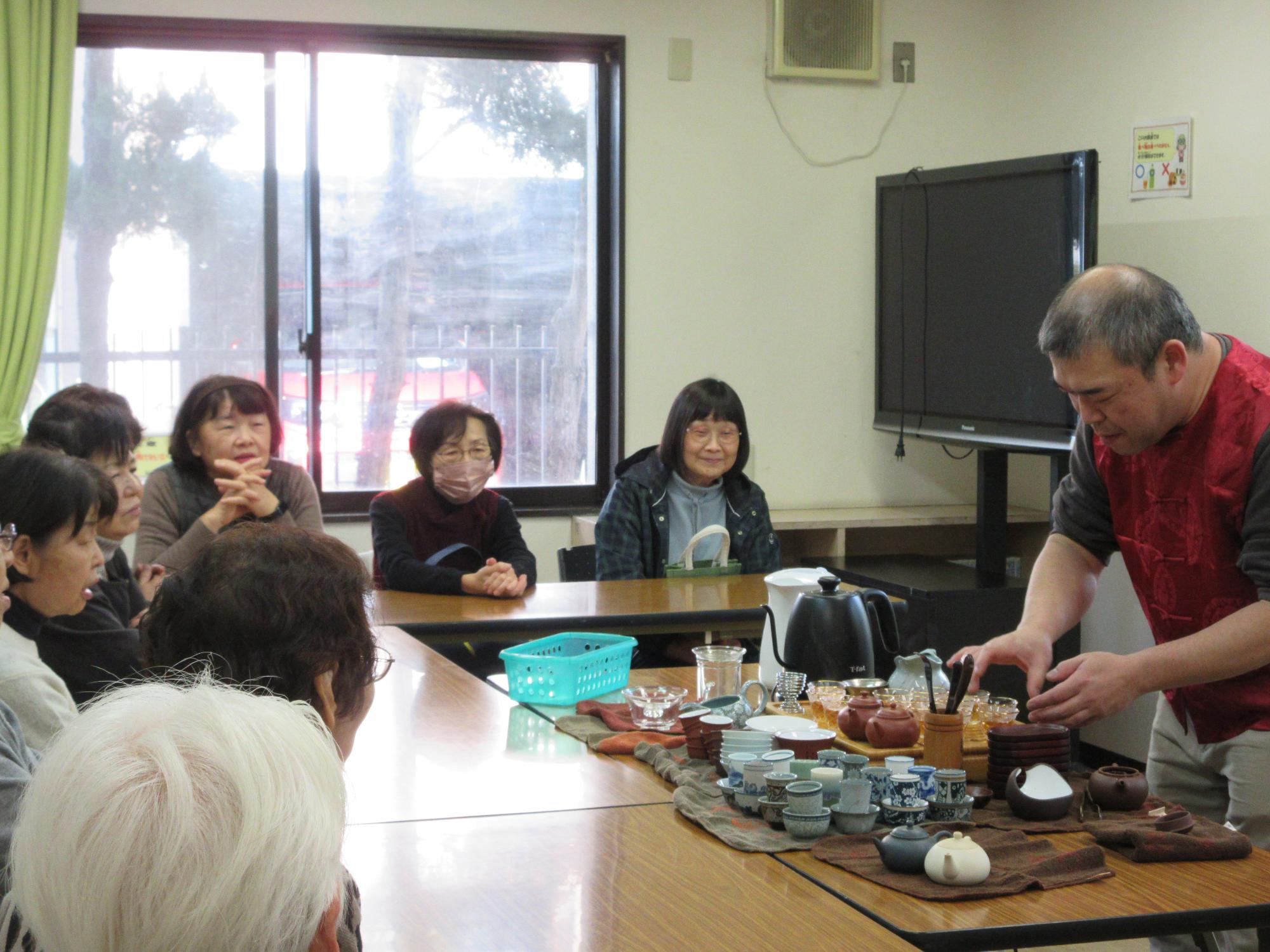 中国茶を淹れる講師と話を聞く参加者
