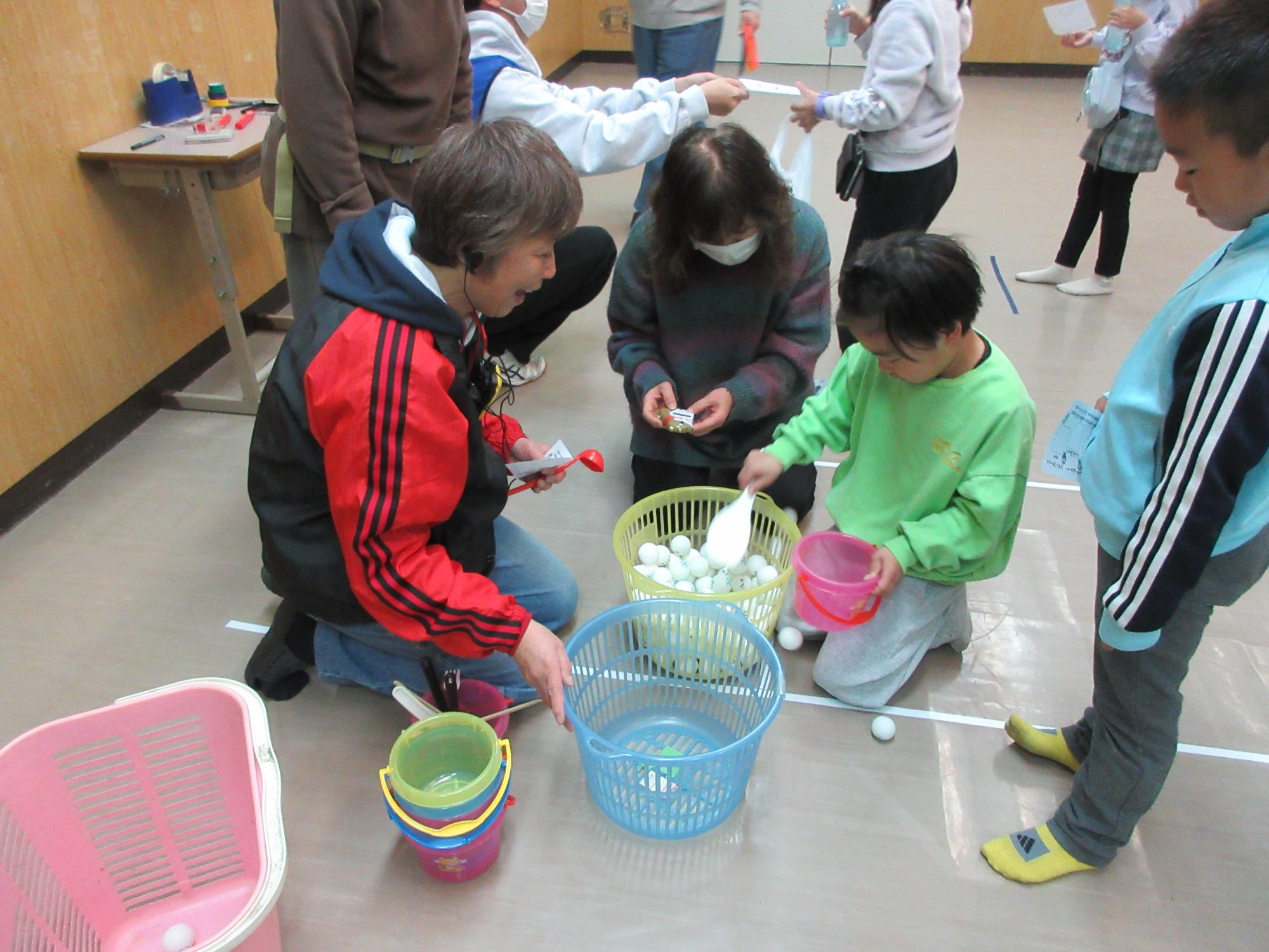 児童がピンポン玉すくいで遊んでいる様子