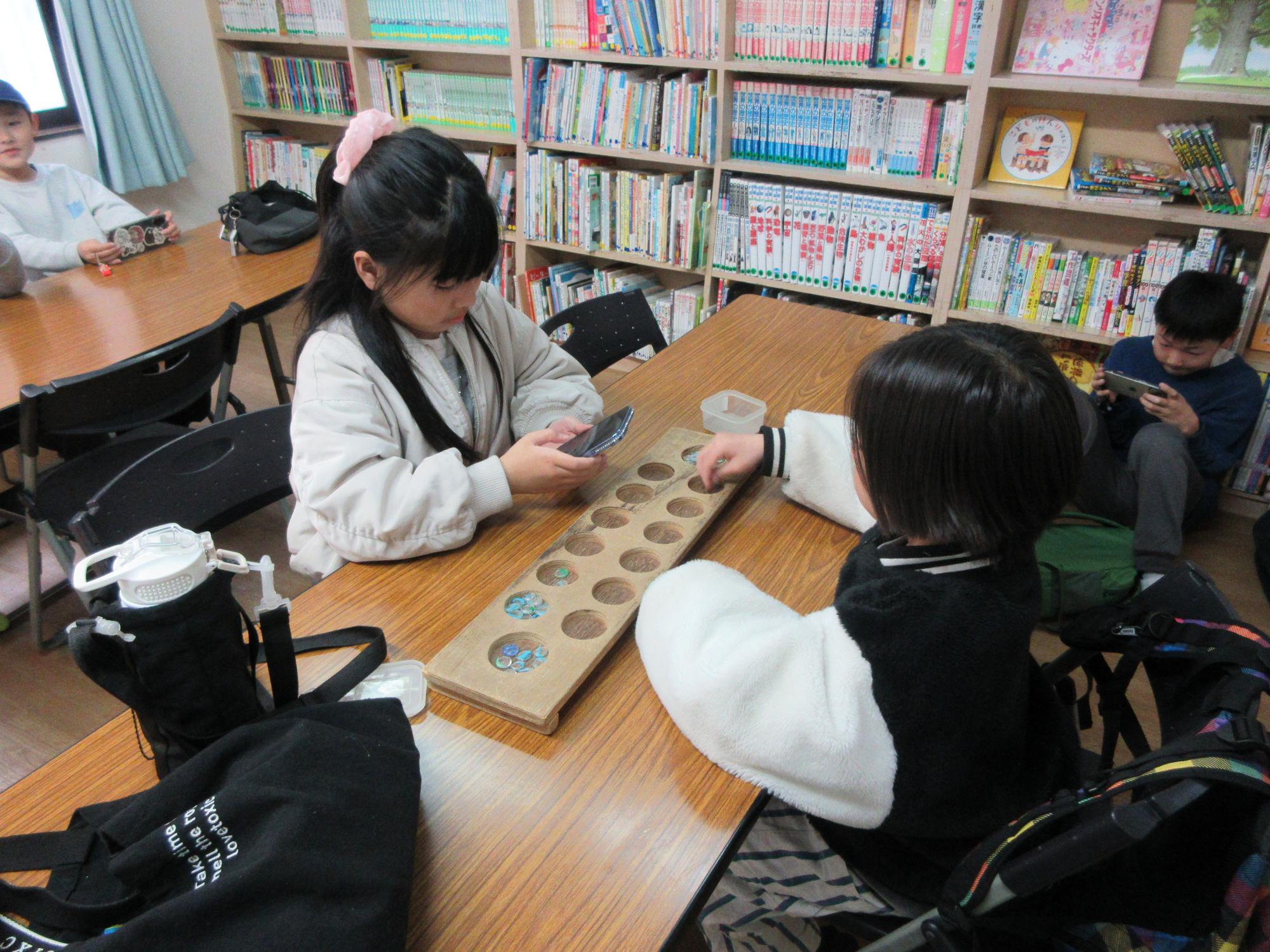 児童がマンカラをしている様子