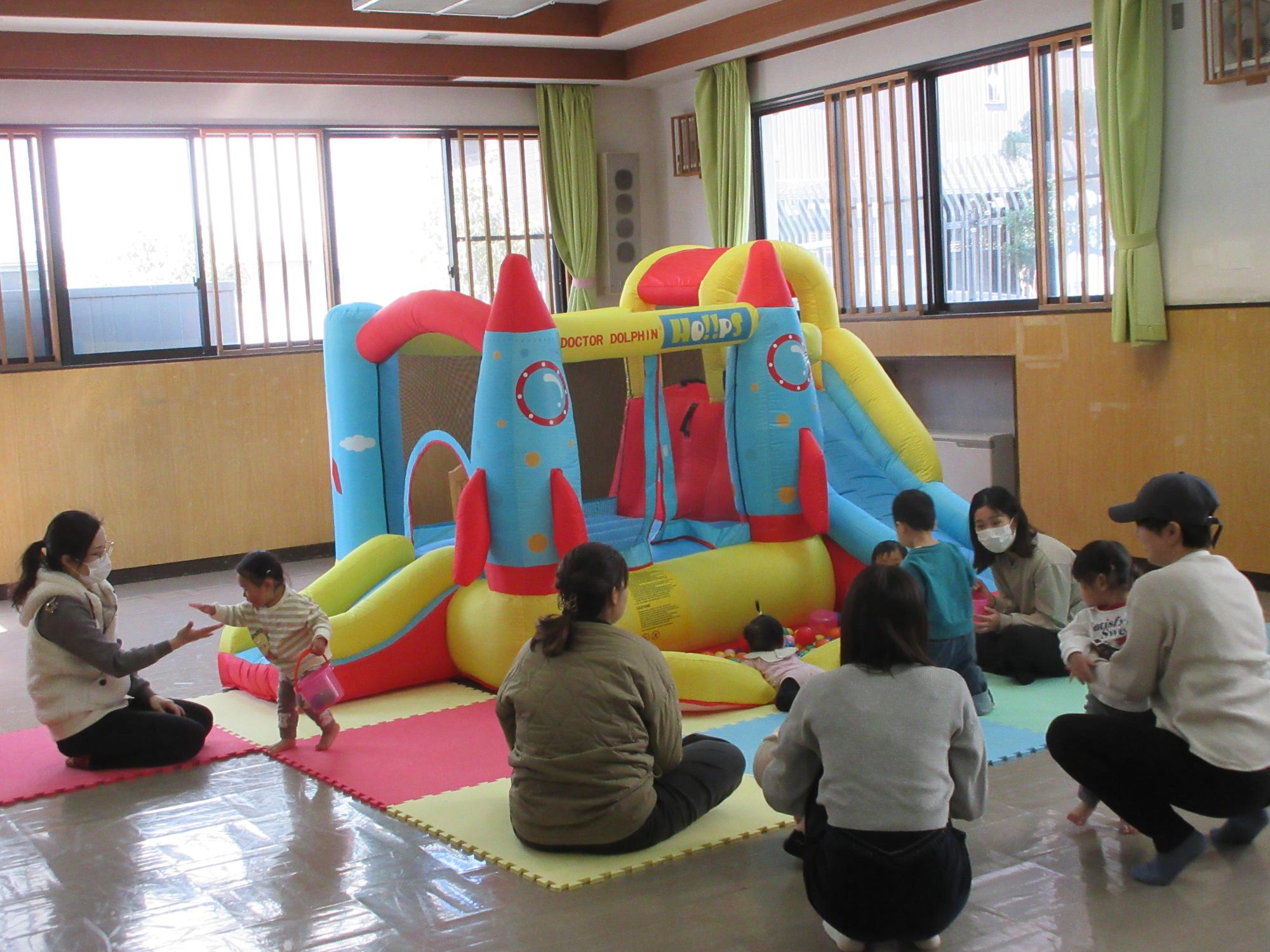 乳幼児親子がジャンピングスライダーで遊んでいる様子