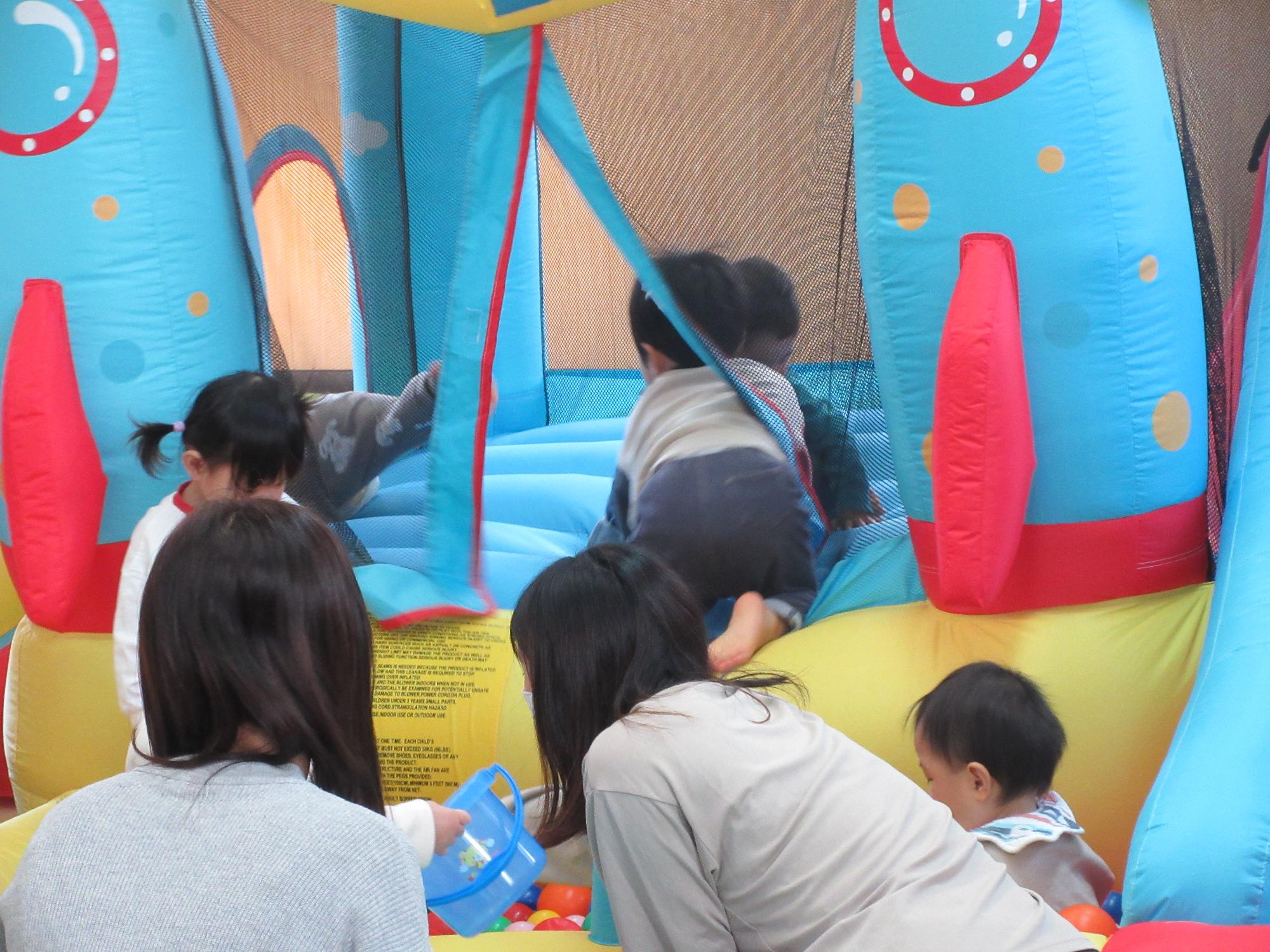 乳幼児親子がジャンピングスライダーで遊んでいる様子