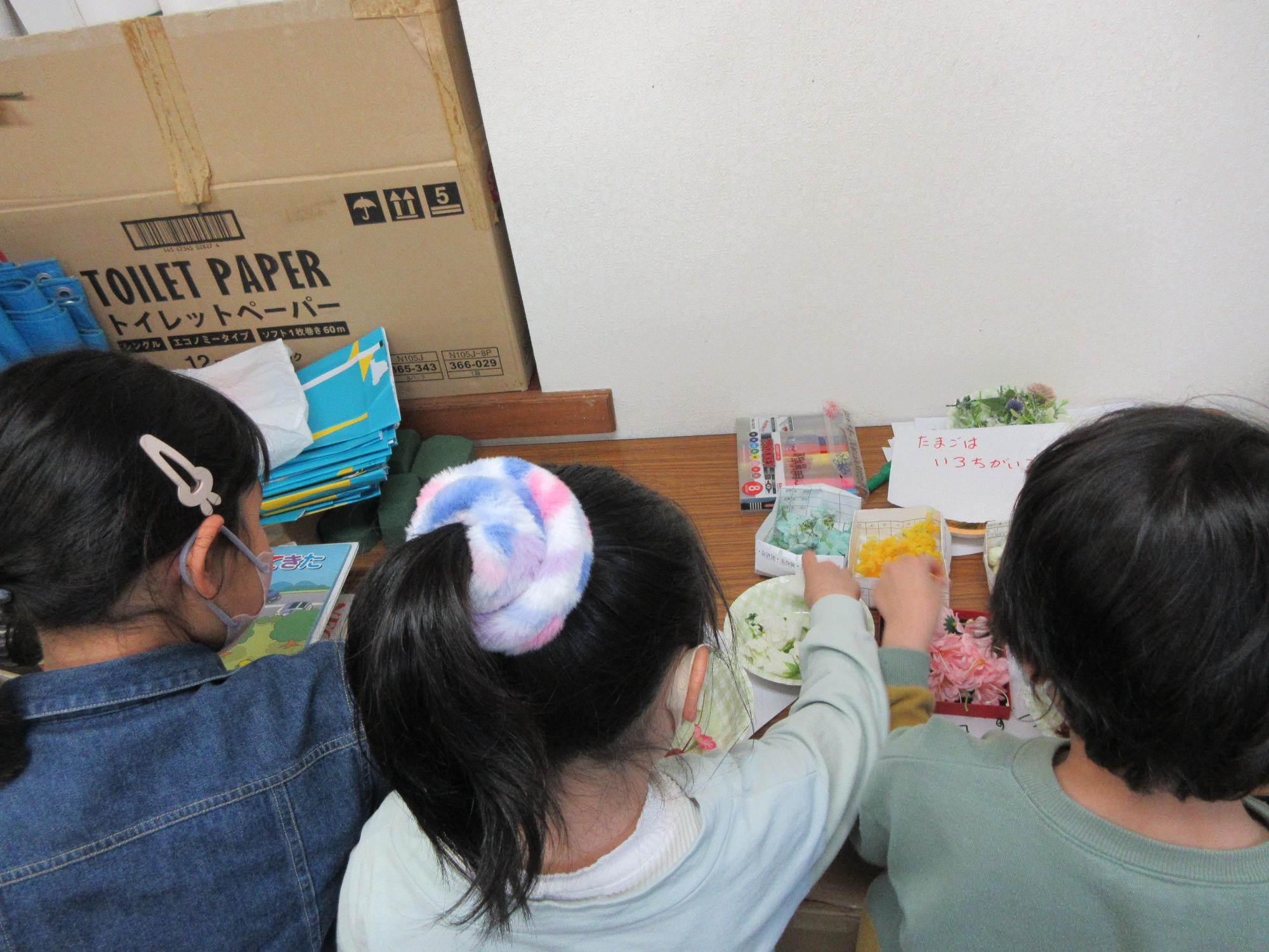 児童たちがフラワーアレンジメントの材料を選んでいる様子