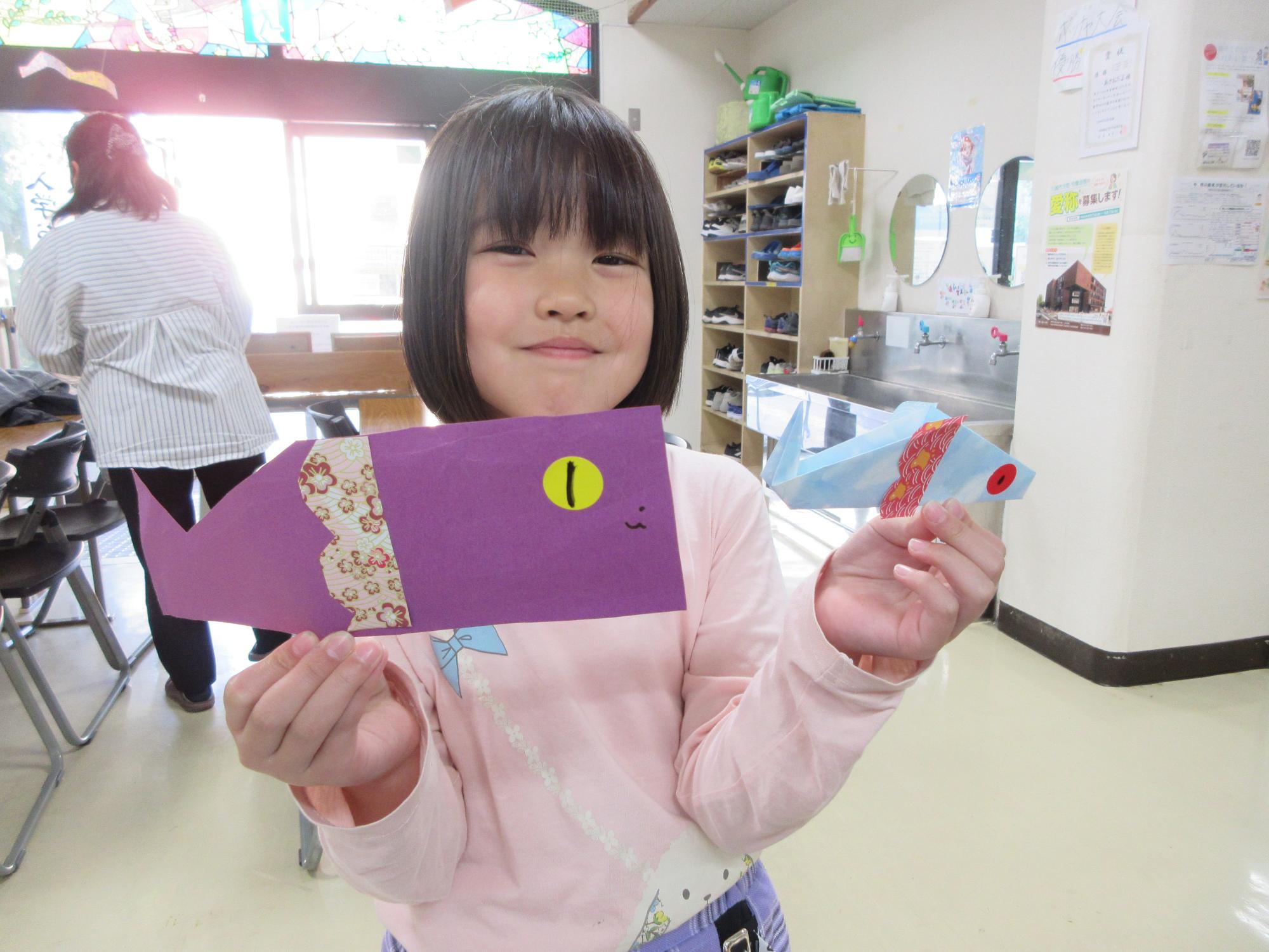 色画用紙で作ったこいのぼり製作を持つ児童の写真