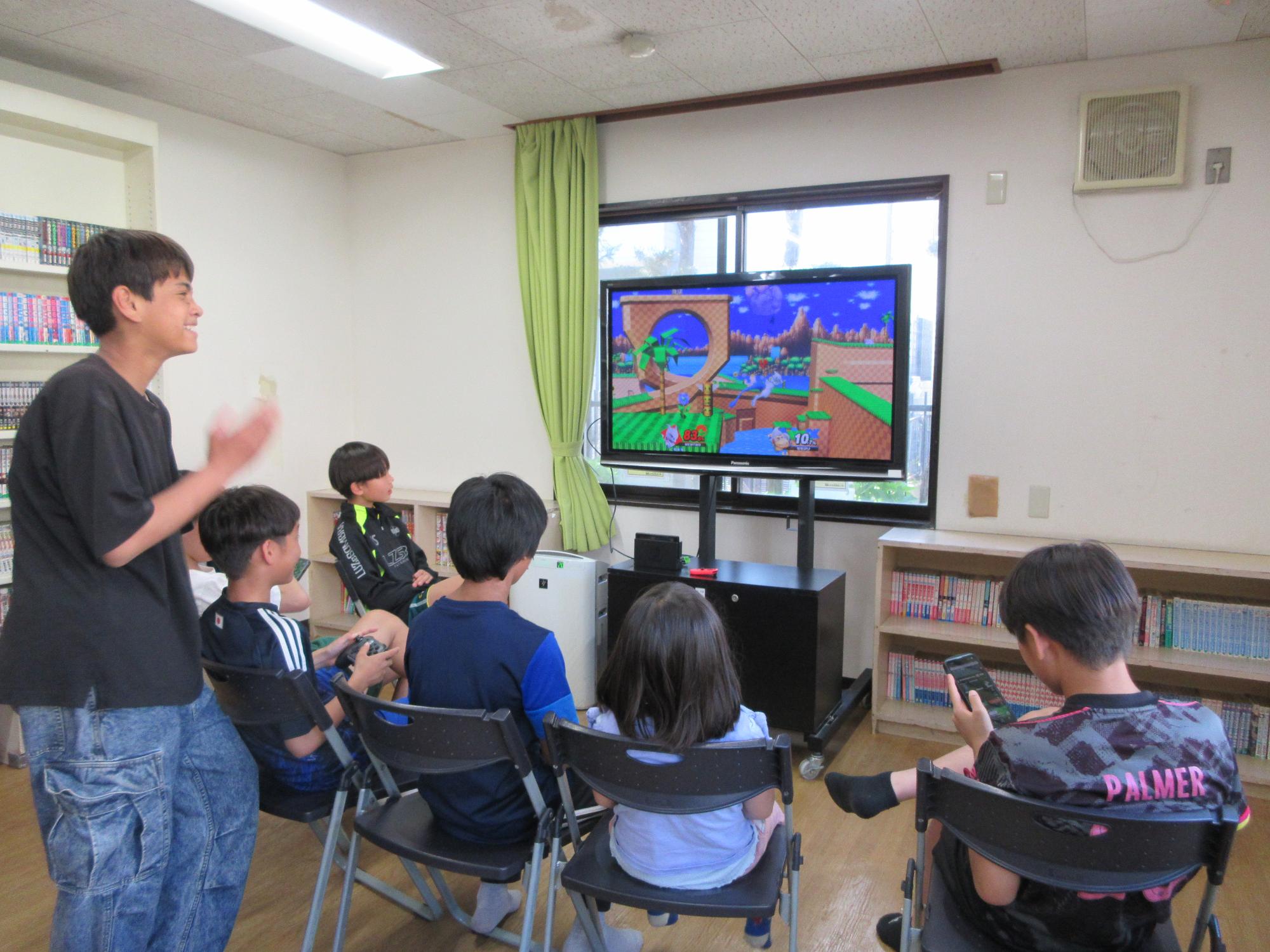 ゲームで対戦する小学生と中学生の様子