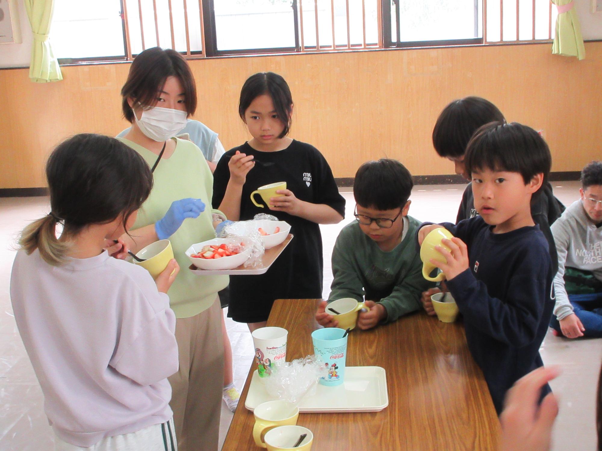 いちごとフルーチェを食べる児童たちの写真