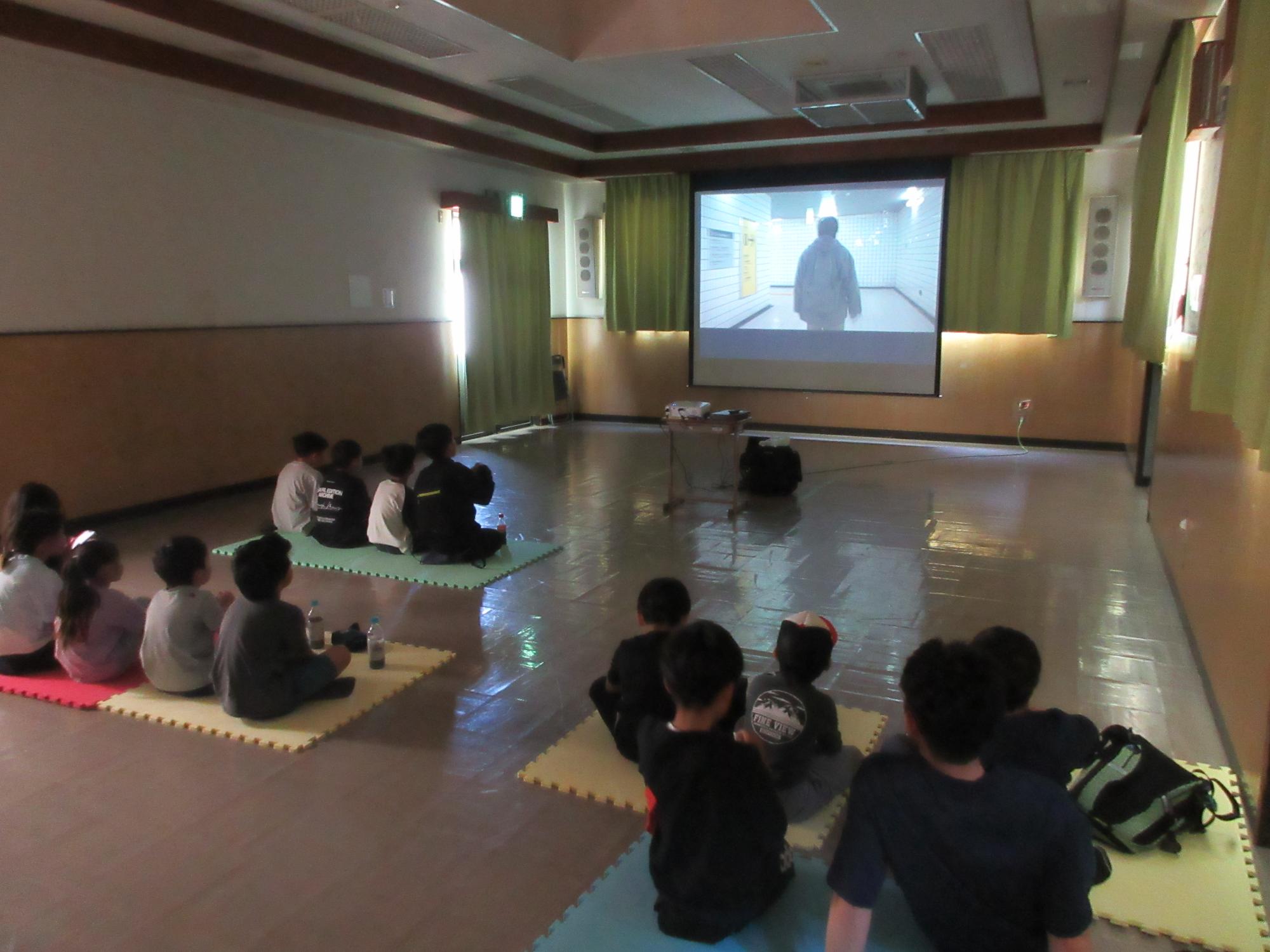 映画を鑑賞する子どもと保護者の様子の写真