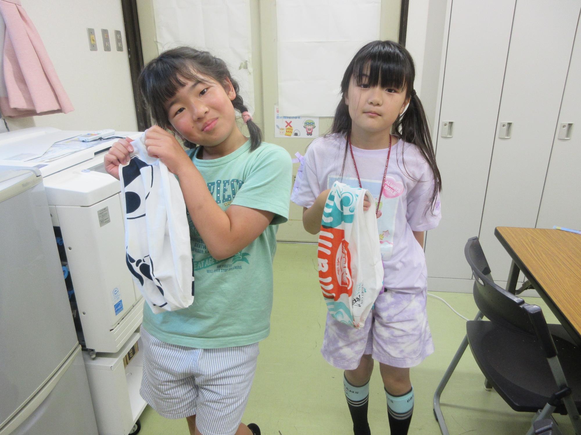 完成したバッグを持つ小学生の様子