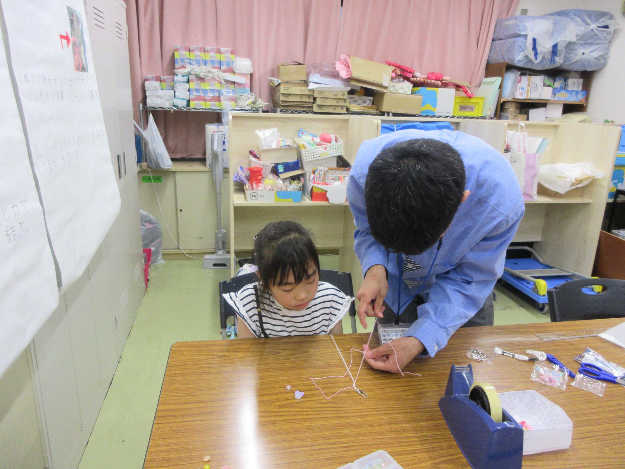 刺しゅう糸を編んでアクセサリーを作る様子