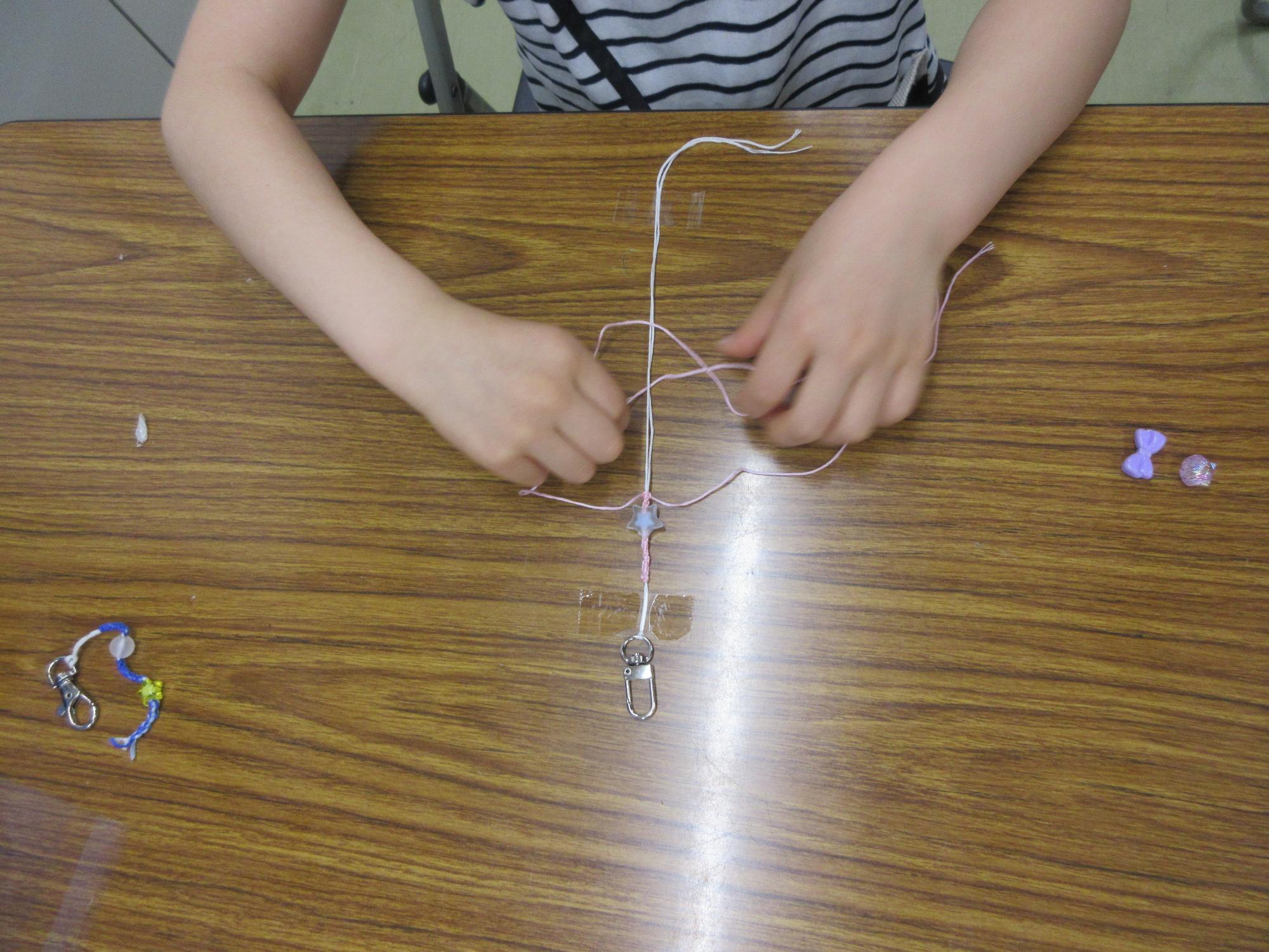 刺しゅう糸を編んでアクセサリーを作る様子