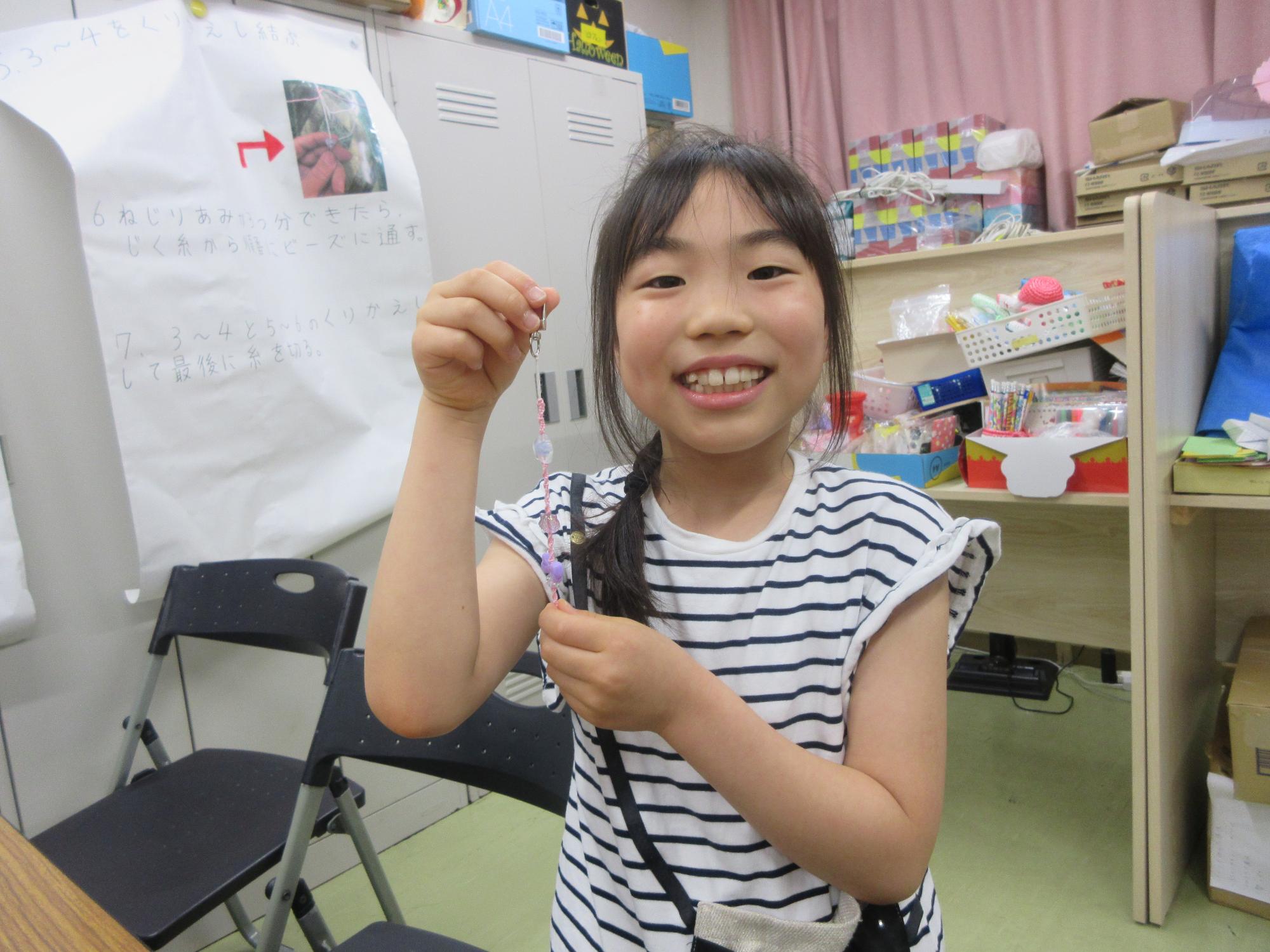 完成したアクセサリーを持つ児童の写真