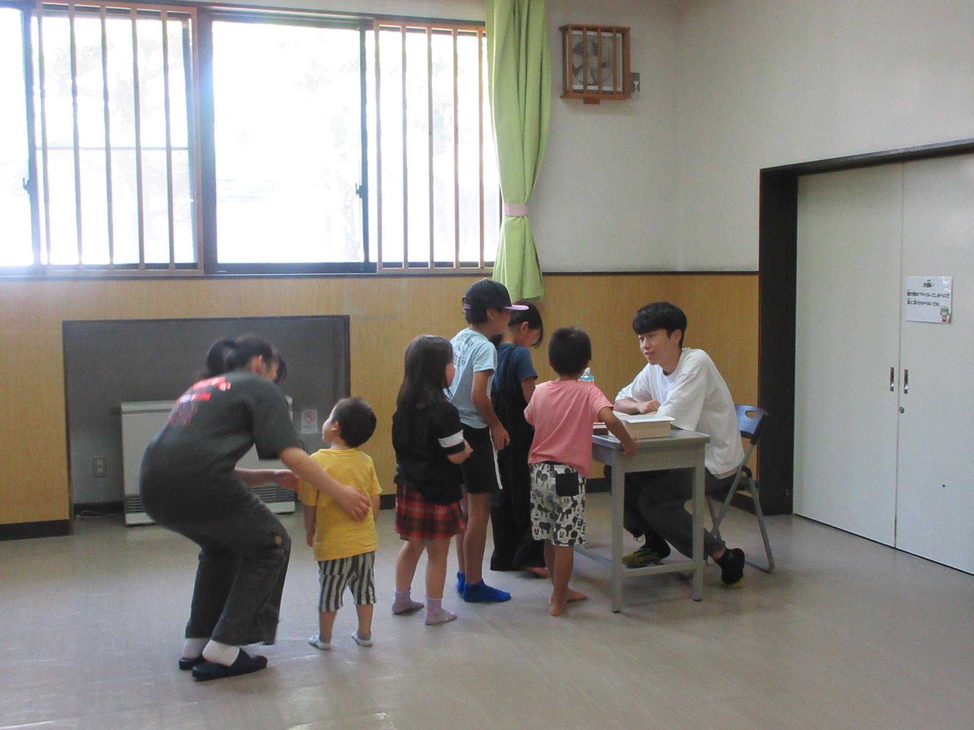 児童たちが景品プレゼントの列に並んでいる様子