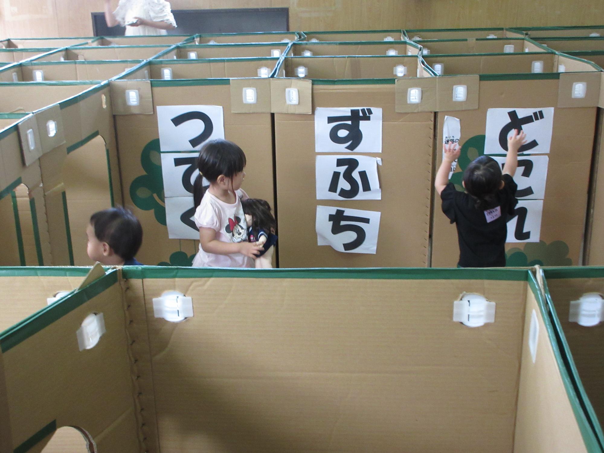 幼児さんたちがダンボールめいろで遊んでいる様子