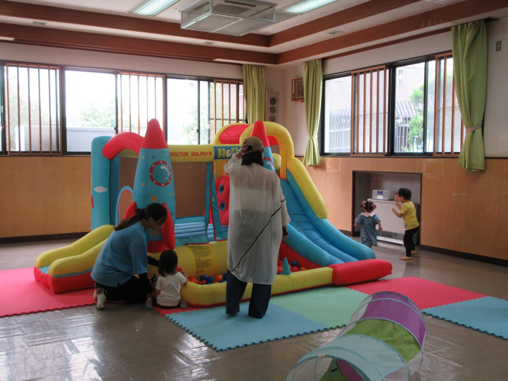 幼児親子たちがジャンピングスライダーで遊んでいる様子