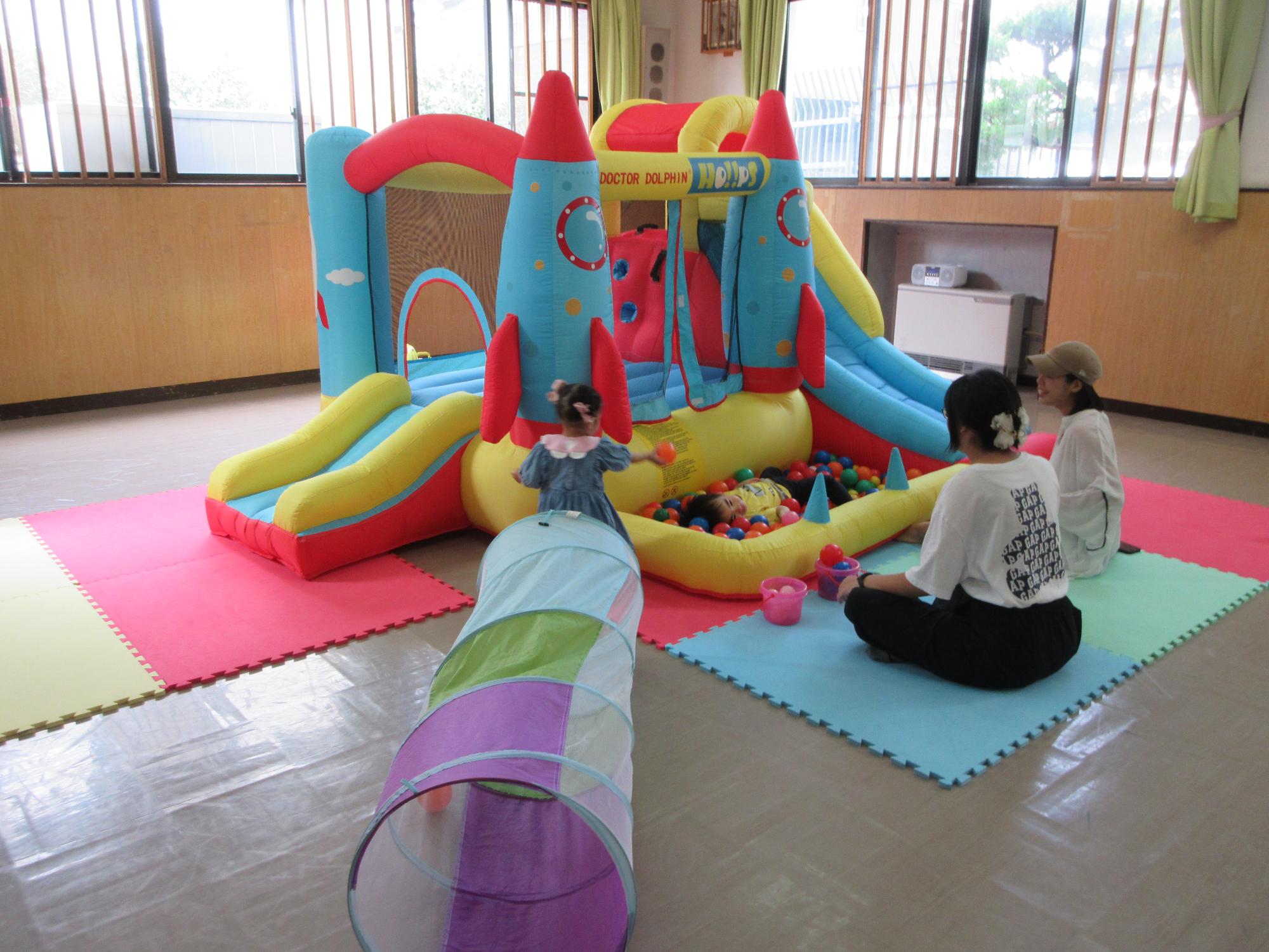 幼児親子たちがジャンピングスライダーで遊んでいる様子