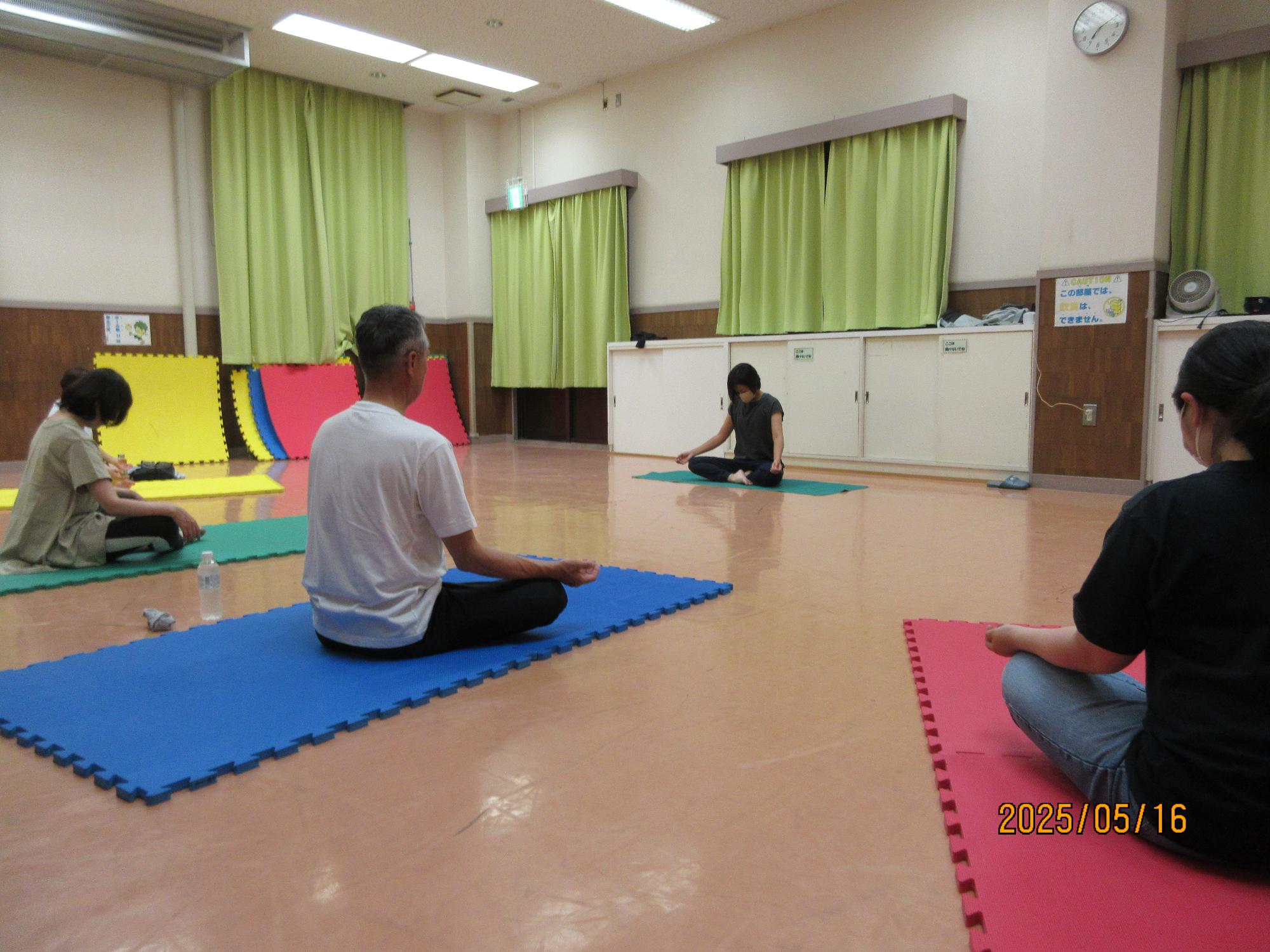 集会室でヨガをしているところの写真