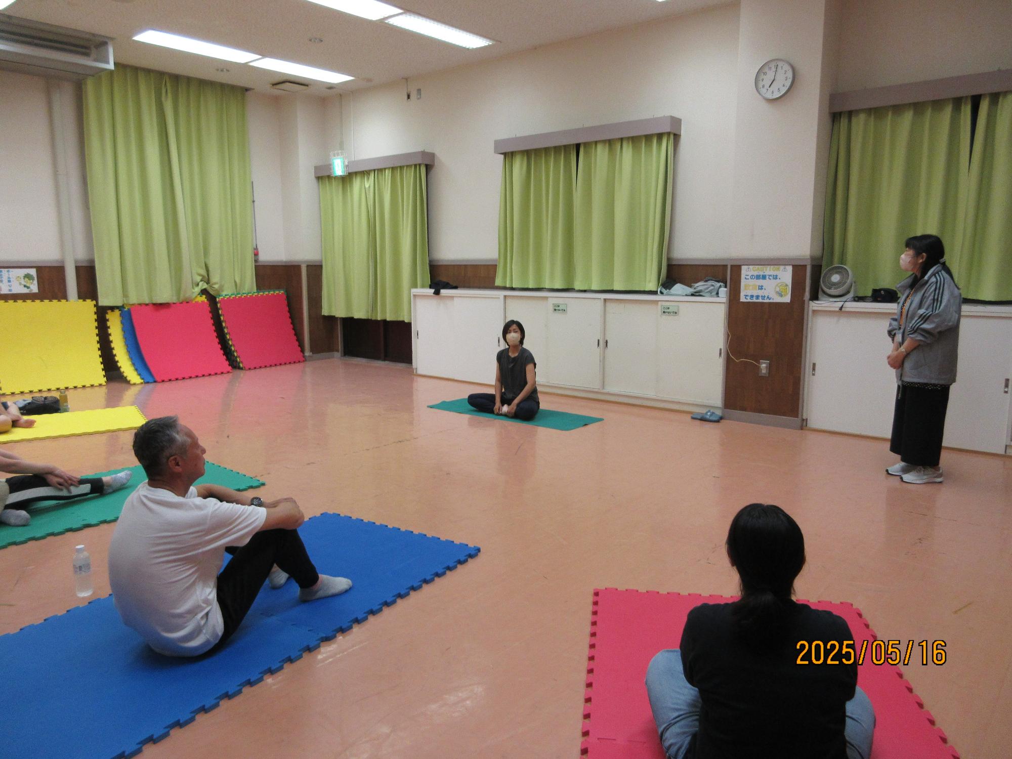 集会室でヨガをしているところの写真