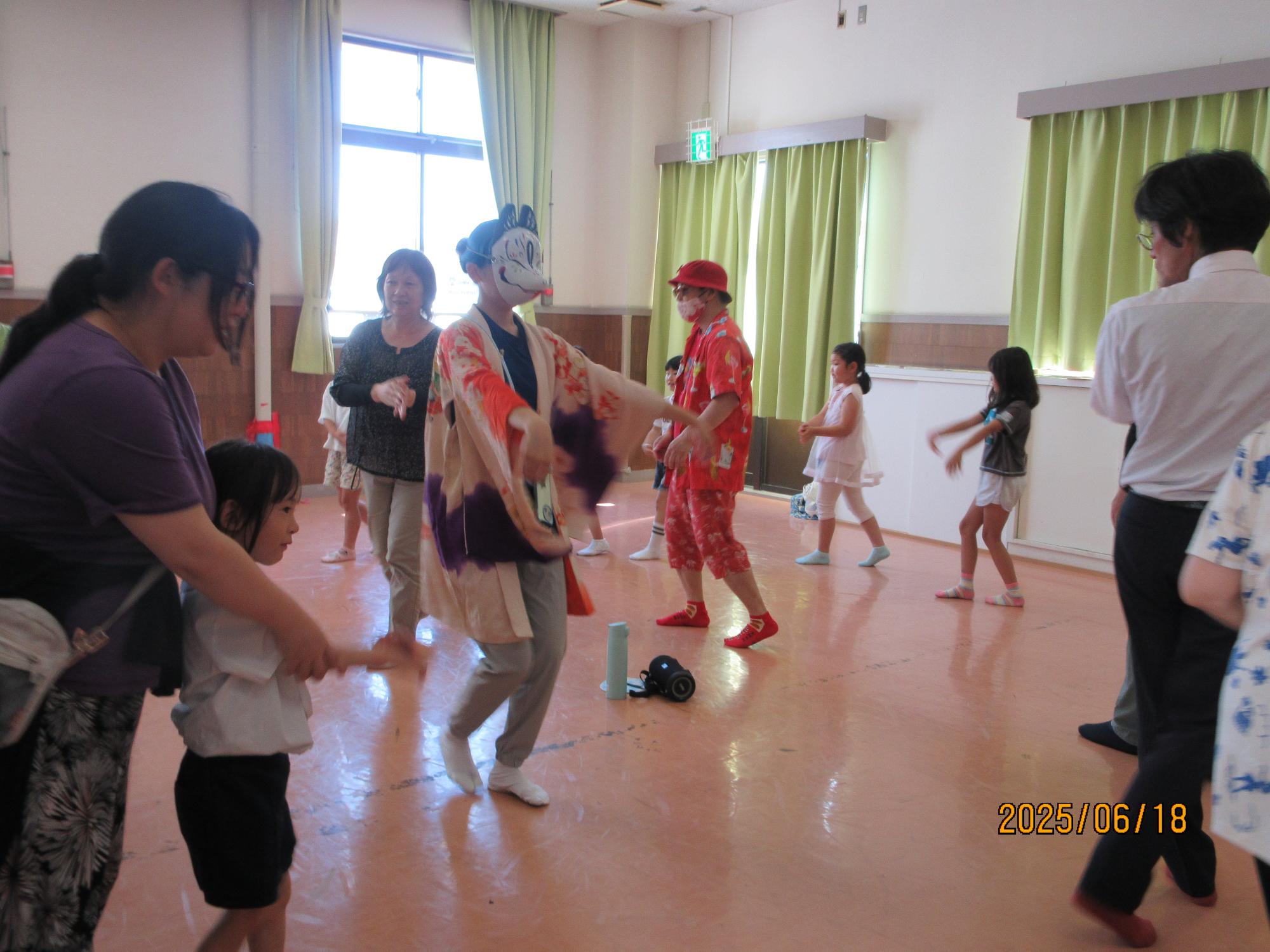 集会室で盆踊りを踊っているところの写真