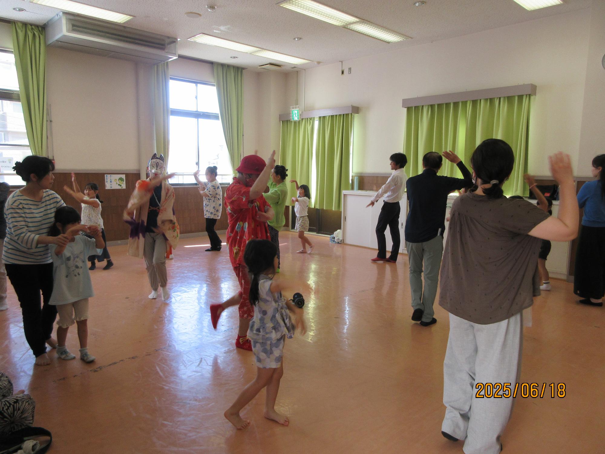 集会室で盆踊りを踊っているところの写真