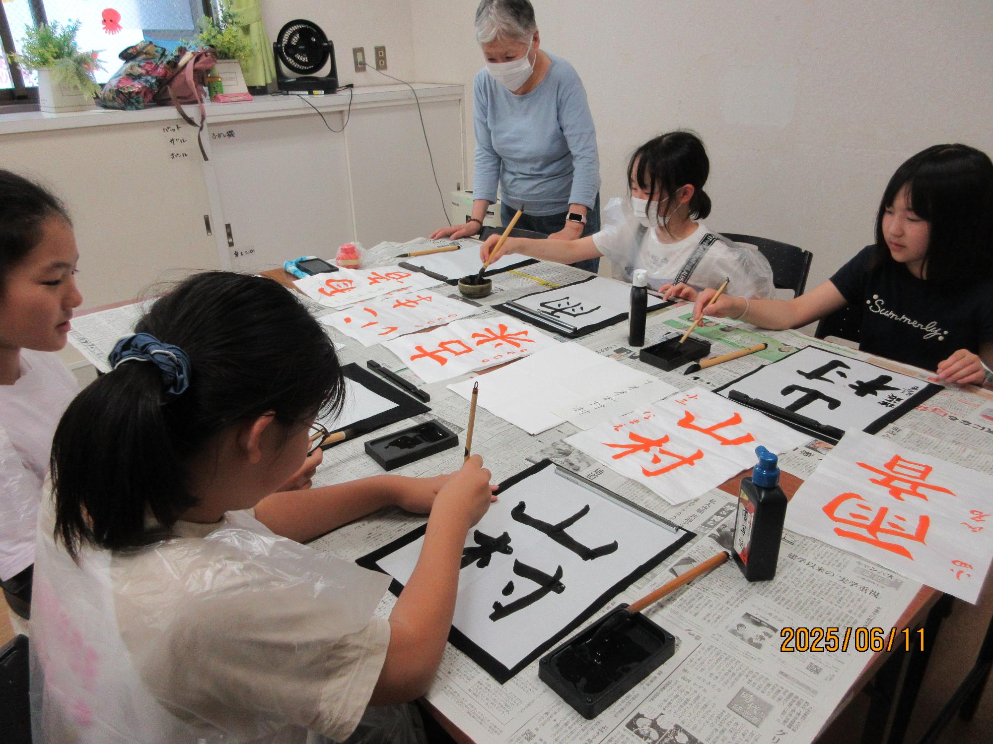 学習室で子ども達が習字をしているところの写真