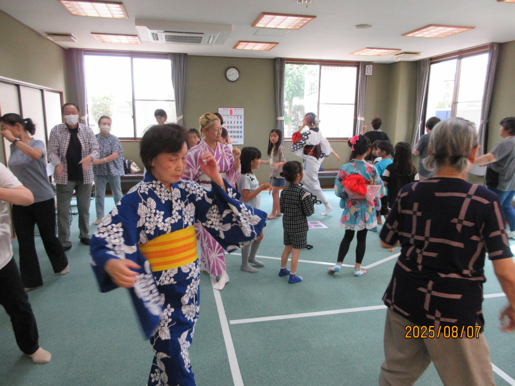 いこいの家の大広間に集まり盆踊りを楽しんでいるところの写真