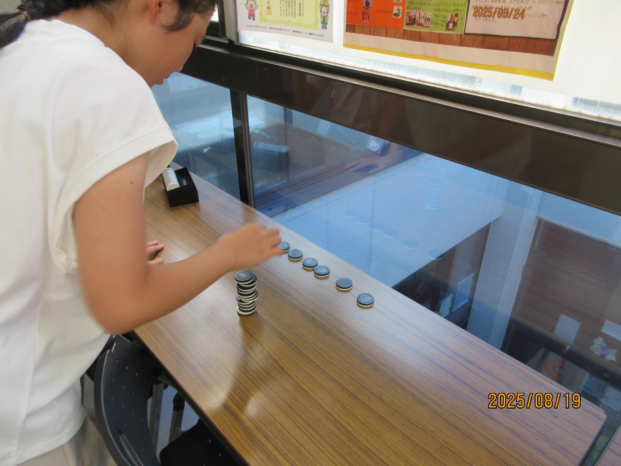 オセロのコマを、積み上げているところの写真