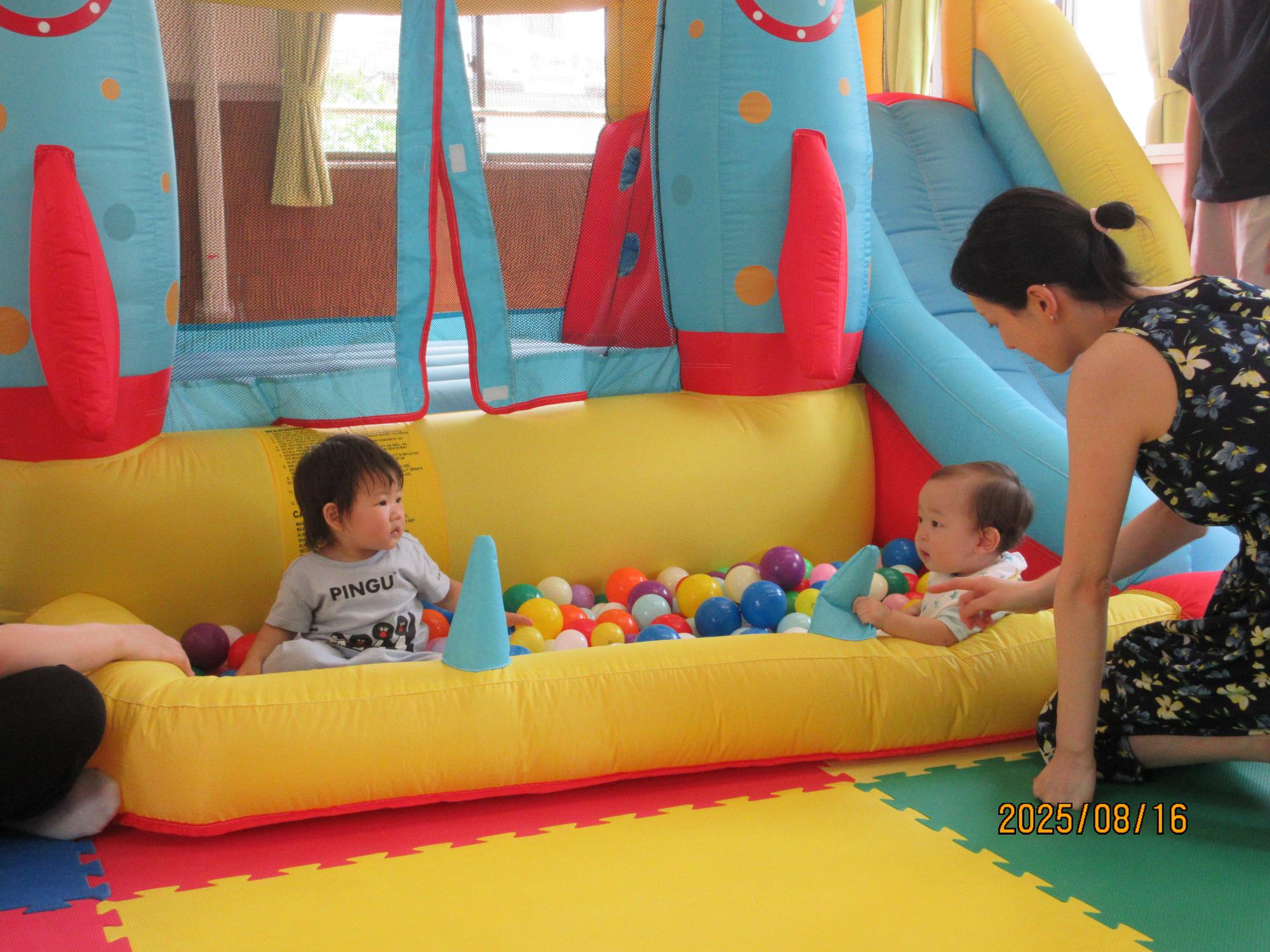 集会室でジャンピングスライダーに入ってい遊んでいるところの写真