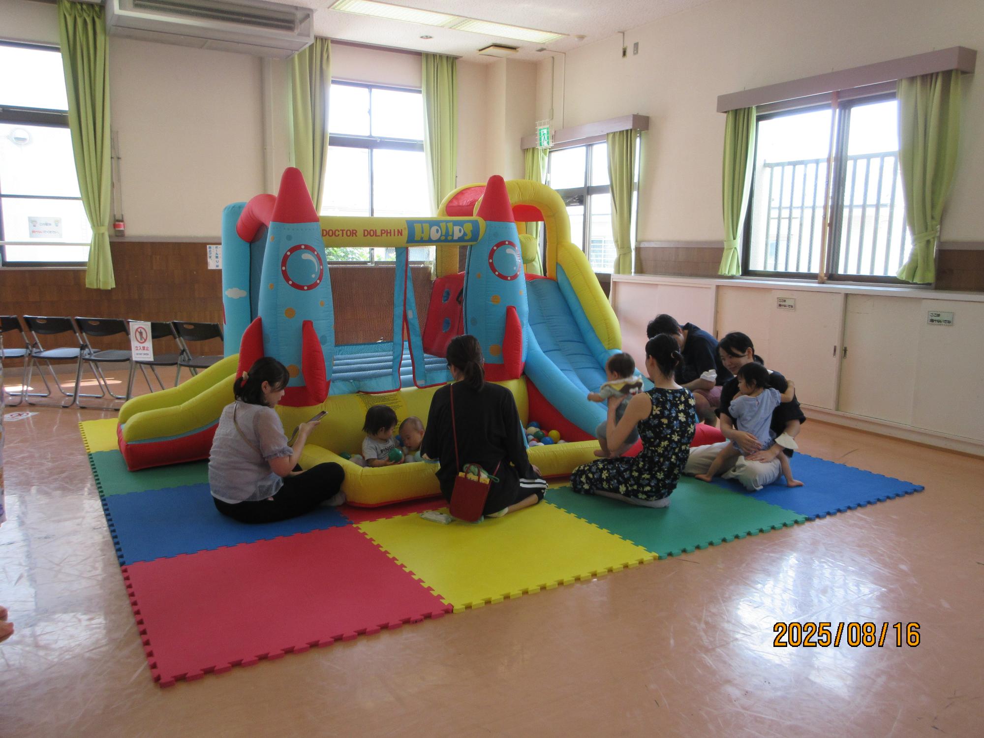 集会室でジャンピングスライダーに入ってい遊んでいるところの写真